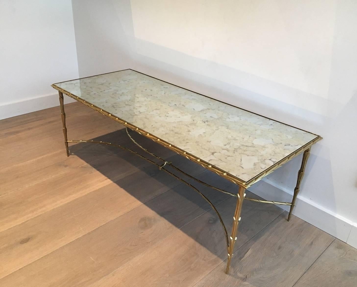 Faux bamboo bronze coffee table with antique mirror top by Maison Bagués.