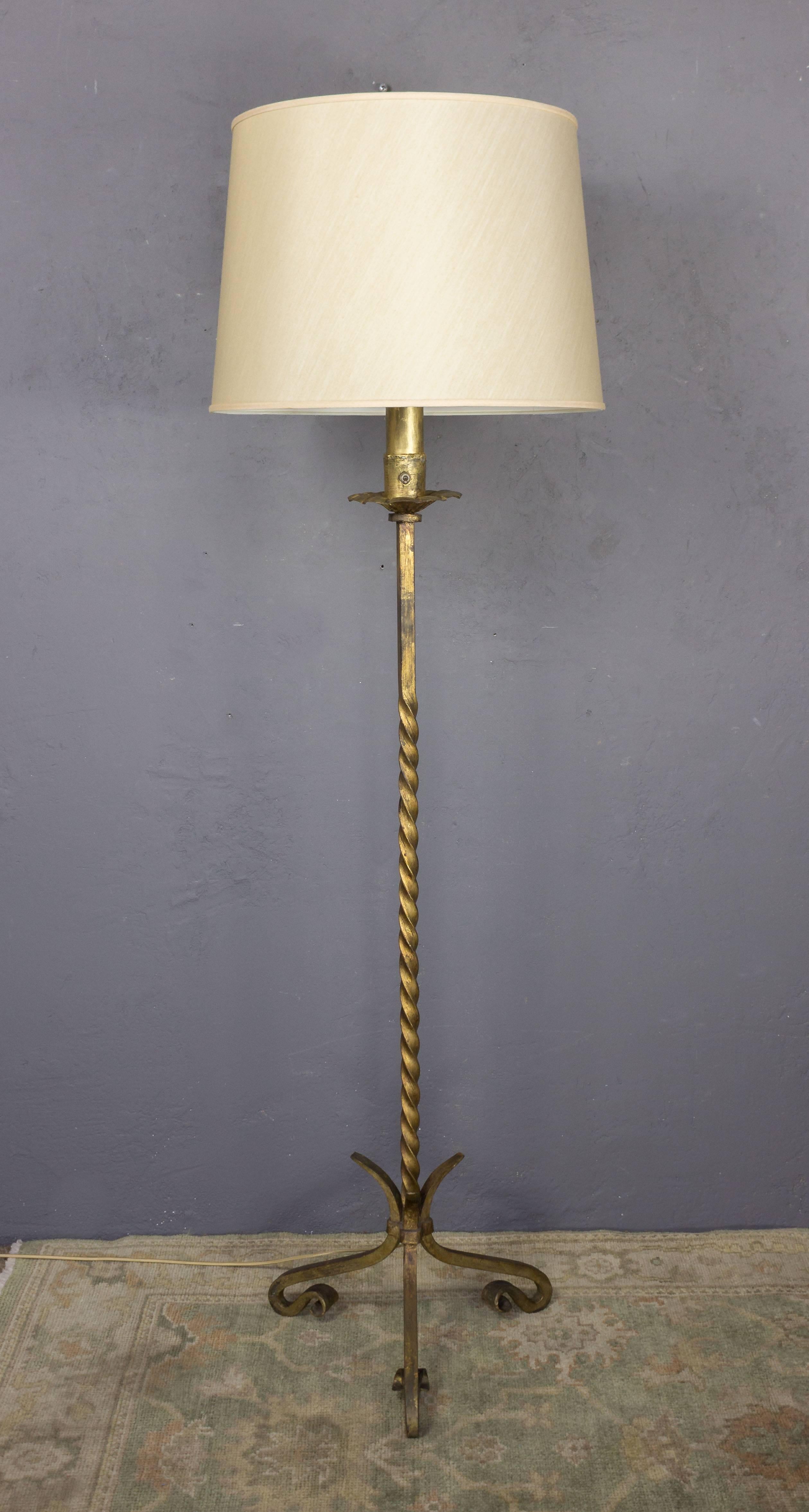 Pair of Spanish gilt iron floor lamps with a twisted stem and a tripod base with inverted and curved feet. Not sold with shades, circa 1940s.