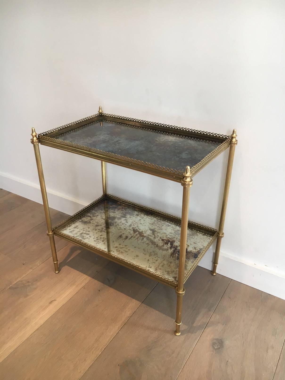 French 1940s two-tiered side table with gallery. The table is made of brass with antiqued mirror shelves. 

This table is currently in France, please allow 3 to 6 weeks delivery. Price includes delivery to our warehouse in Long Island City, NY