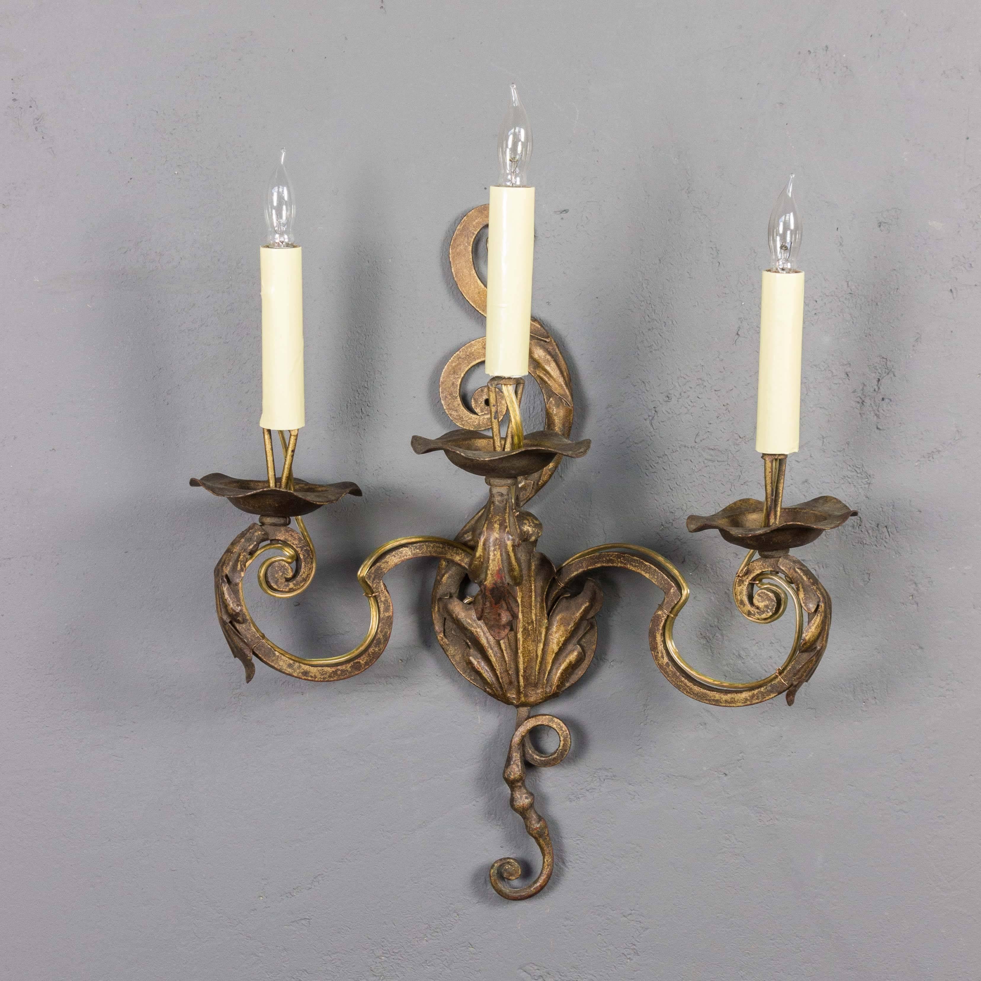 Pair of gilt metal, three armed sconces, wrought iron with applied leaf decorations, French, 1920s. Rewired (not UL listed). Measures: 16