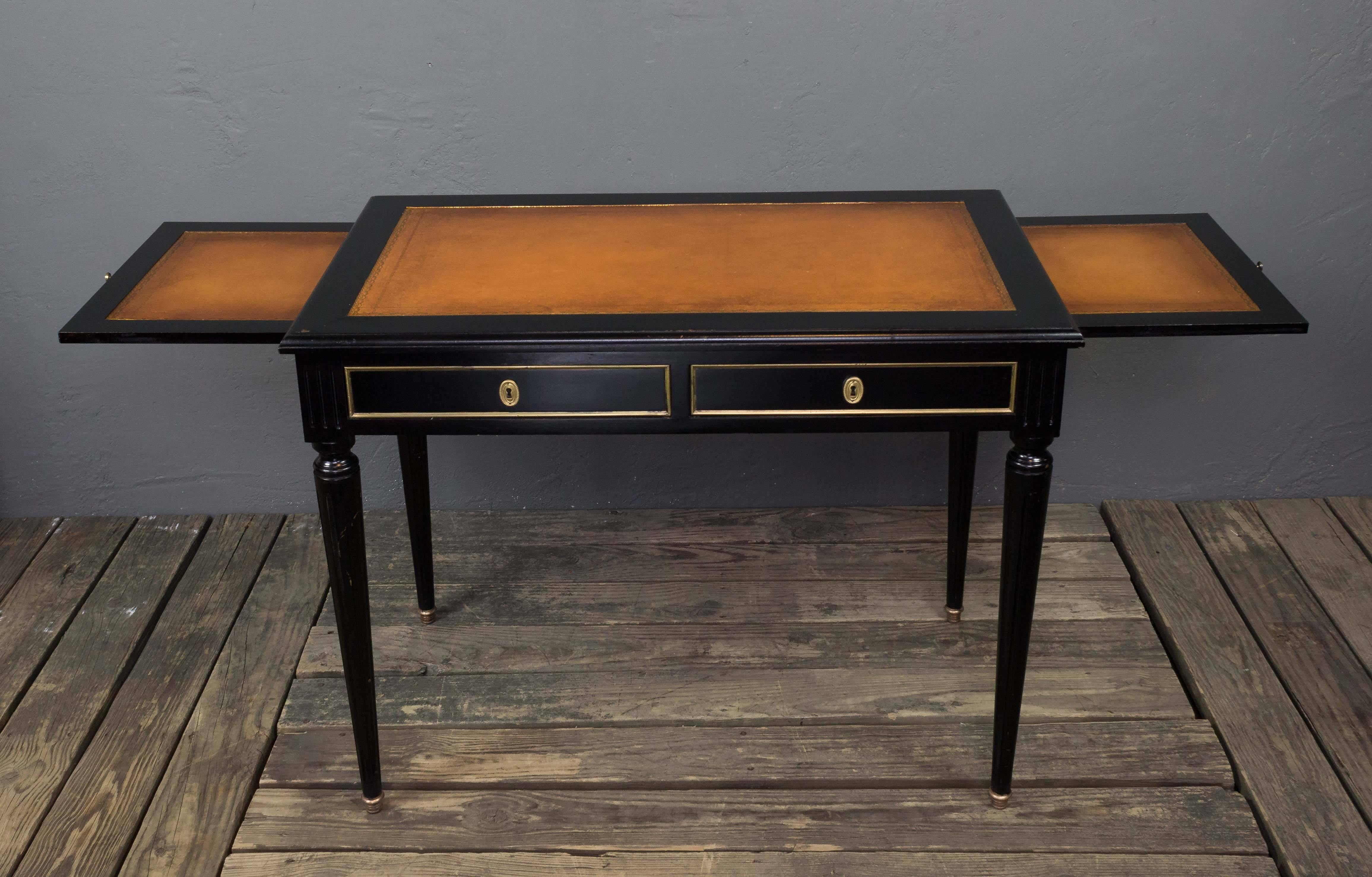 An ebonized Louis XVI style leather top writing table with leather pull-out slides, 
France, circa 1950

Measures: 30