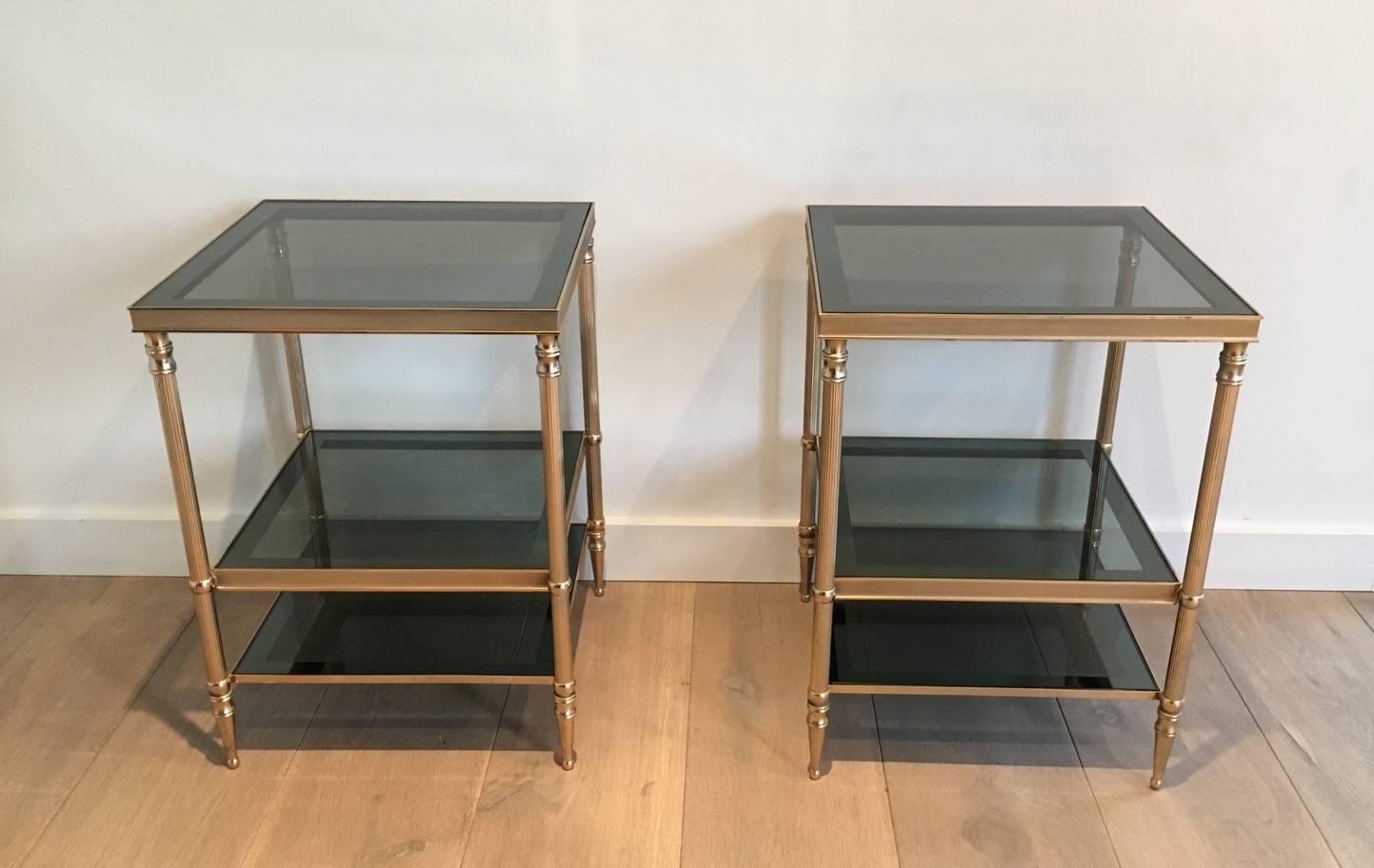 Handsome pair of brass side tables with three grey glass shelves. French 1940s in the style of Maison Jensen.

These tables are currently in France, please allow 3 to 6 weeks delivery. Price includes delivery to New York.