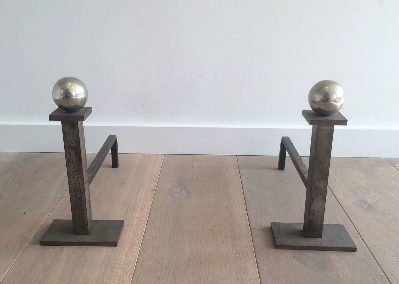 Pair of modernist andirons made of patinated brushed steel square elements with a chrome plated balls.

This item is currently in France, please allow 2 to 4 weeks delivery to New York. Shipping costs from France to our warehouse in New York