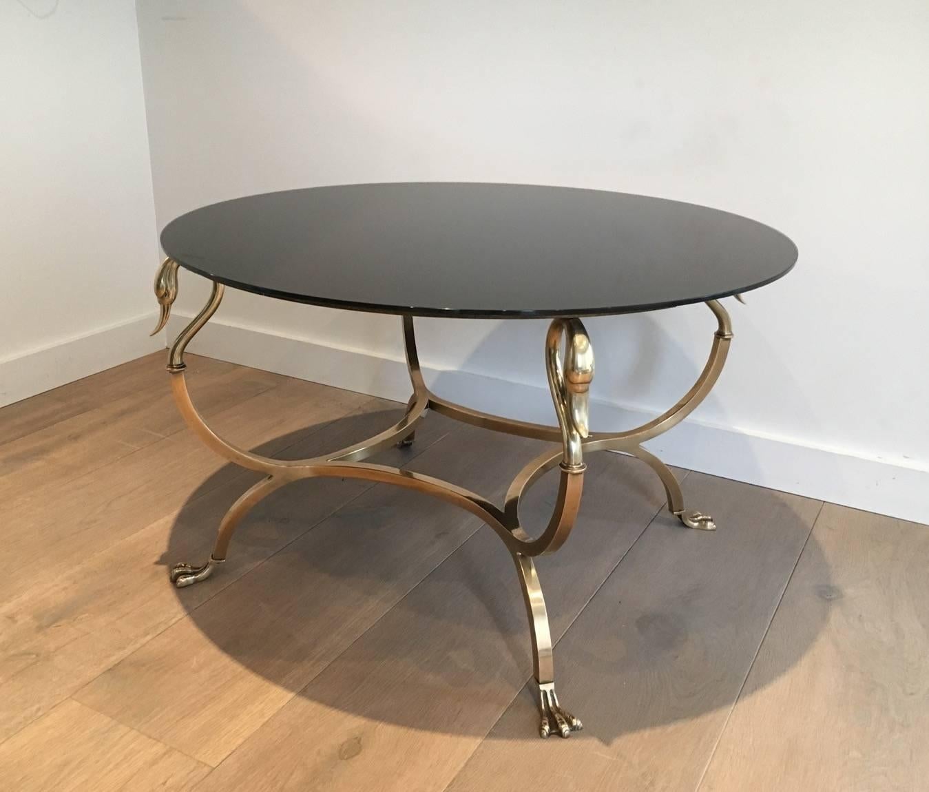 Brass coffee table by Maison Jansen with fine Swanheads and feet with a new black lacquered glass top, French, circa 1940.

This item is currently in France, please allow 2 to 4 weeks delivery to New York. 

Shipping costs from France to our