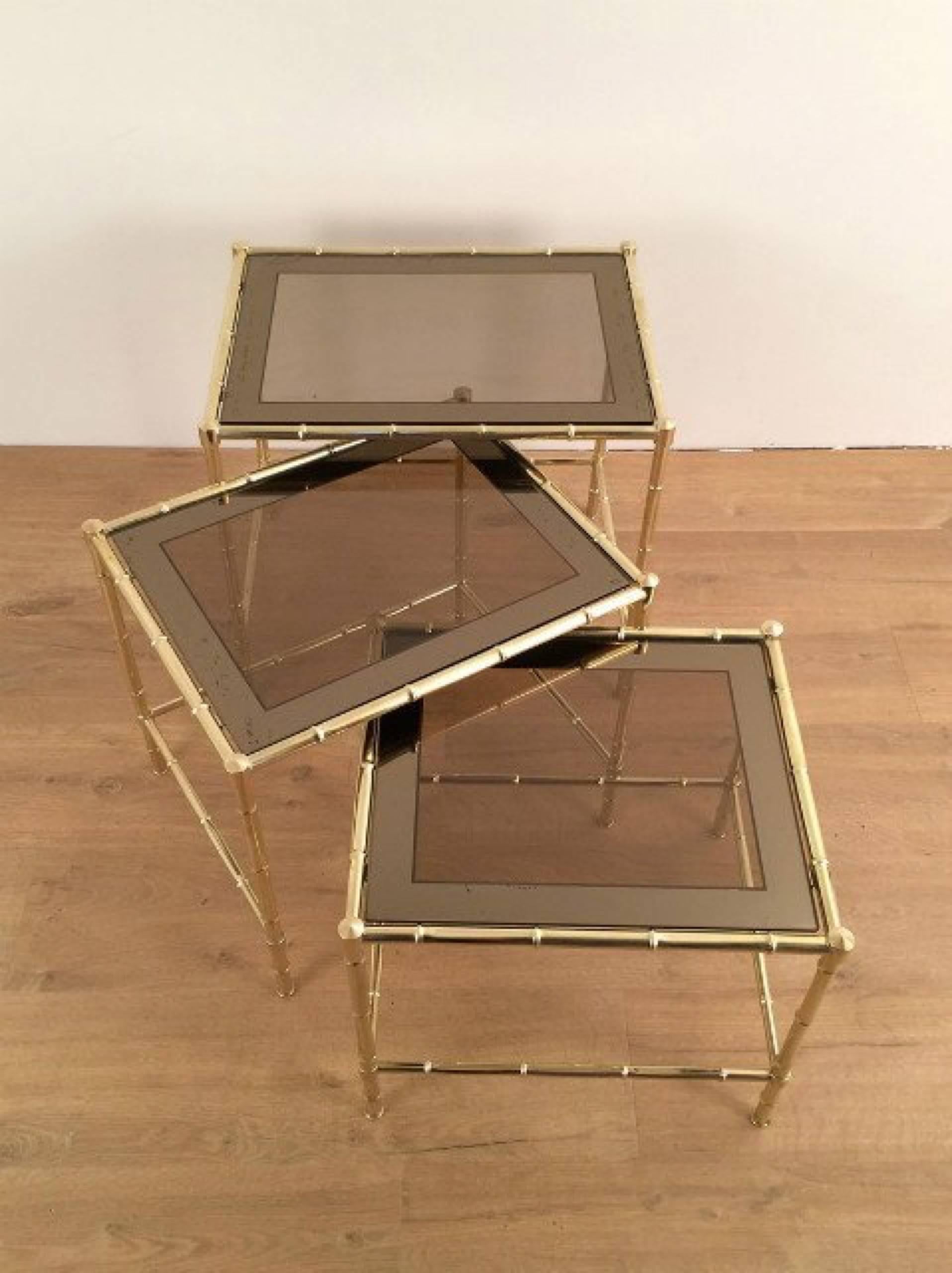 Set of three brass nesting tables in the style of Jacques Adnet. They have their original smoked glass tops that has a darker silvered border on the borrow side of the glass. French, circa 1960


These tables are currently in France, please allow 2