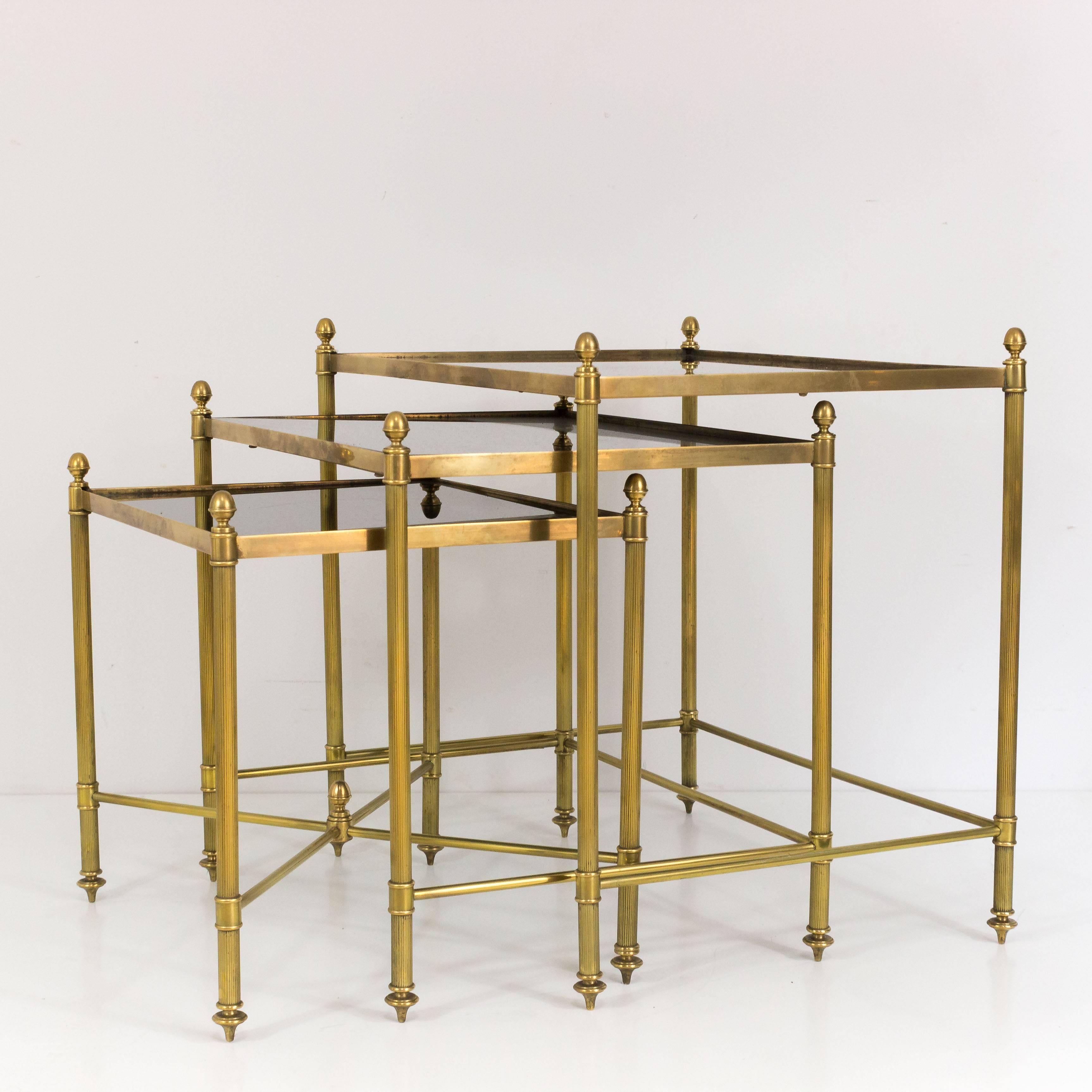 Handsome set of three nesting tables with brass frames and black mirrored glass, French, 1950s.

These tables are currently in France, please allow 2 to 4 weeks delivery to New York. Shipping costs from France to our warehouse in New York included