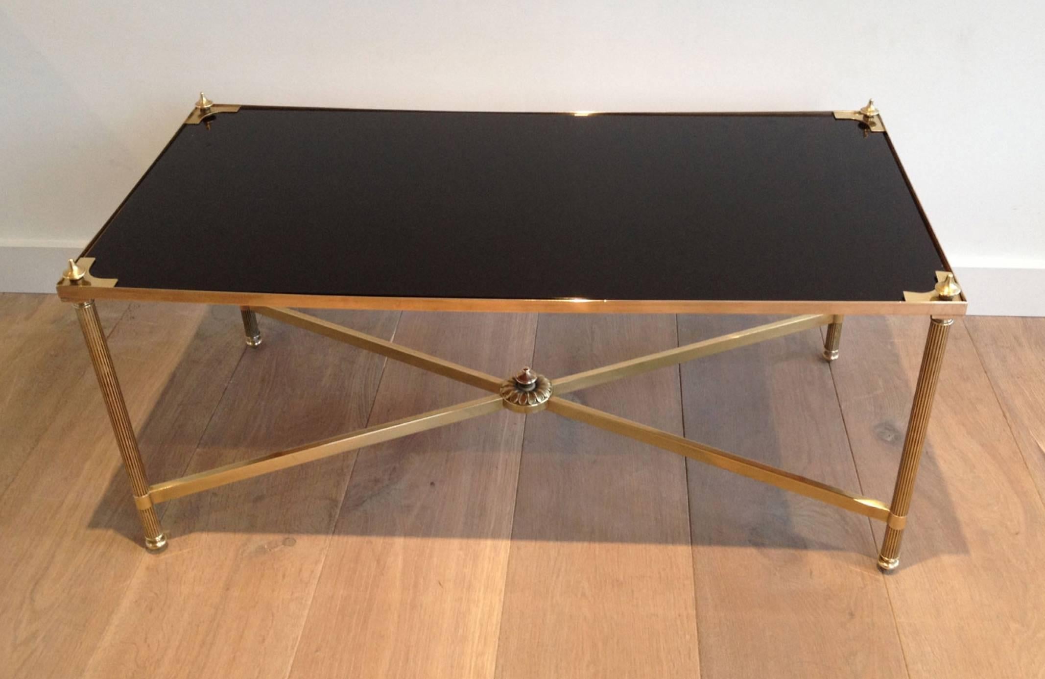 Rectangular brass coffee table with X-stretcher base and black lacquered glass top by Maison Jansen.

This piece is currently in France, please allow 4 to 6 weeks for delivery. Shipping to our warehouse in Long Island City, New York is included in