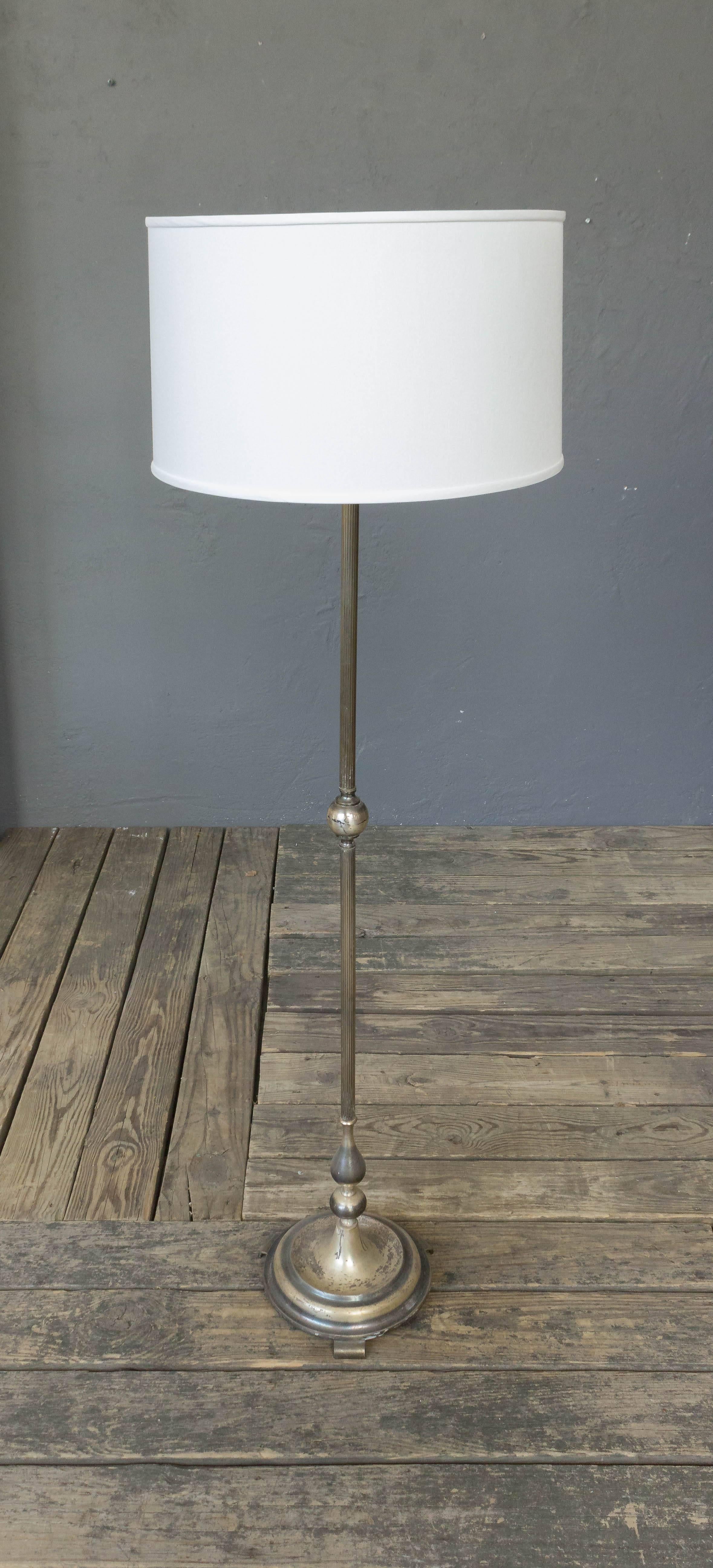 French mid century modern silvered floor lamp on a round base. 

Price includes hand polishing and new wiring. The plating is original and shows tarnishing and wear. The item is listed in good vintage condition but the plating is not new.

Not sold