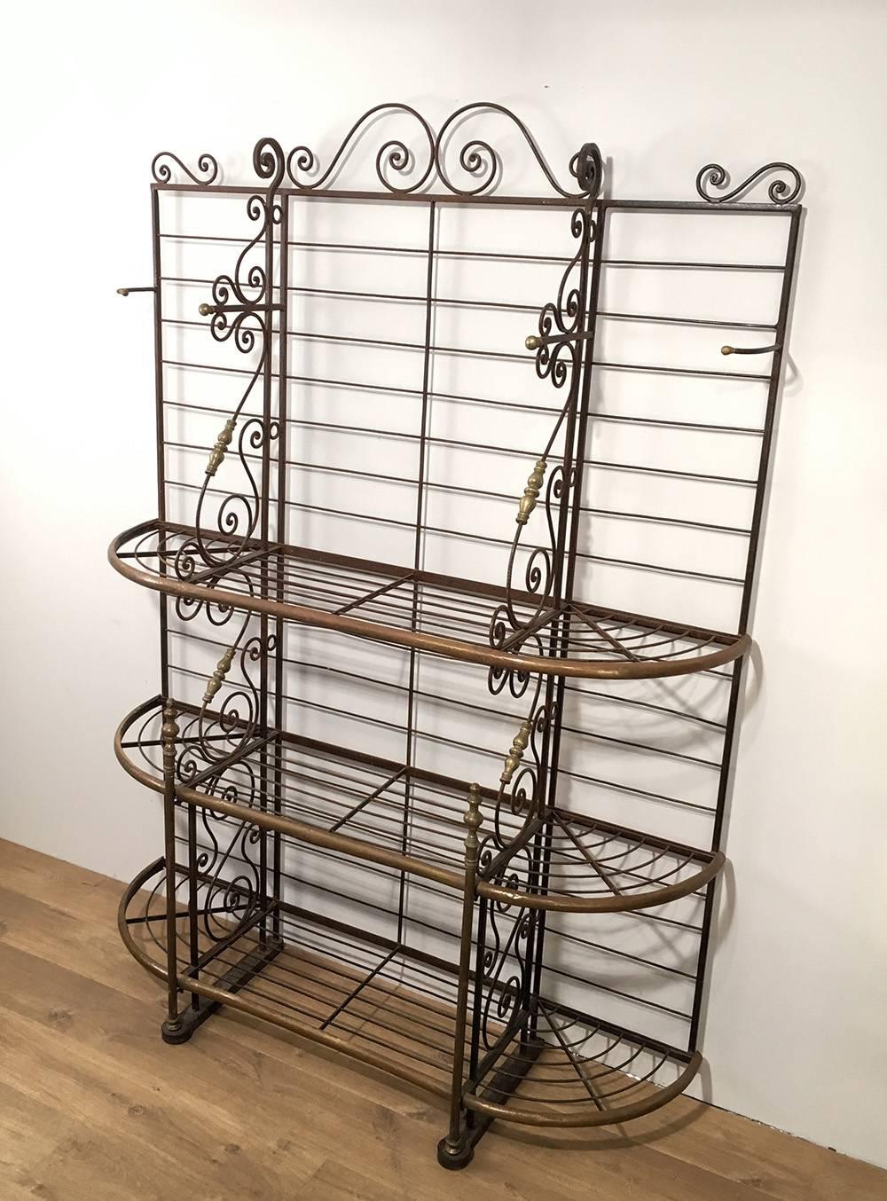 Authentic wrought iron and brass baker's rack with three shelves and hooks for hanging pots or tools. Very well made, French, circa 1950.

This piece is currently in France, please allow 4 to 6 weeks for delivery. Shipping to our warehouse in Long