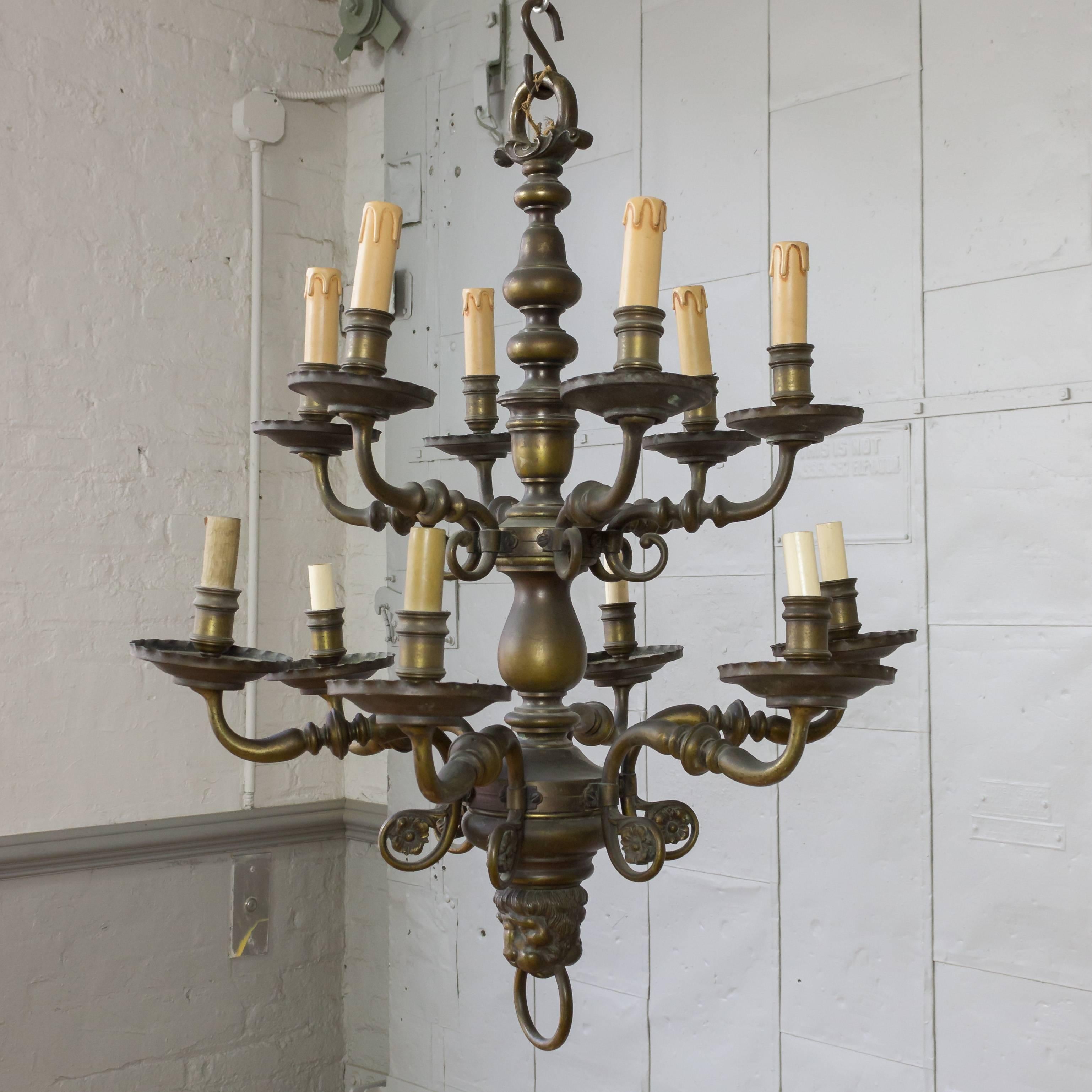 French 1920s neoclassical style bronze and brass double-tiered chandelier with 12 arms. This fixture has been rewired, but it is not UL Code. 


 
