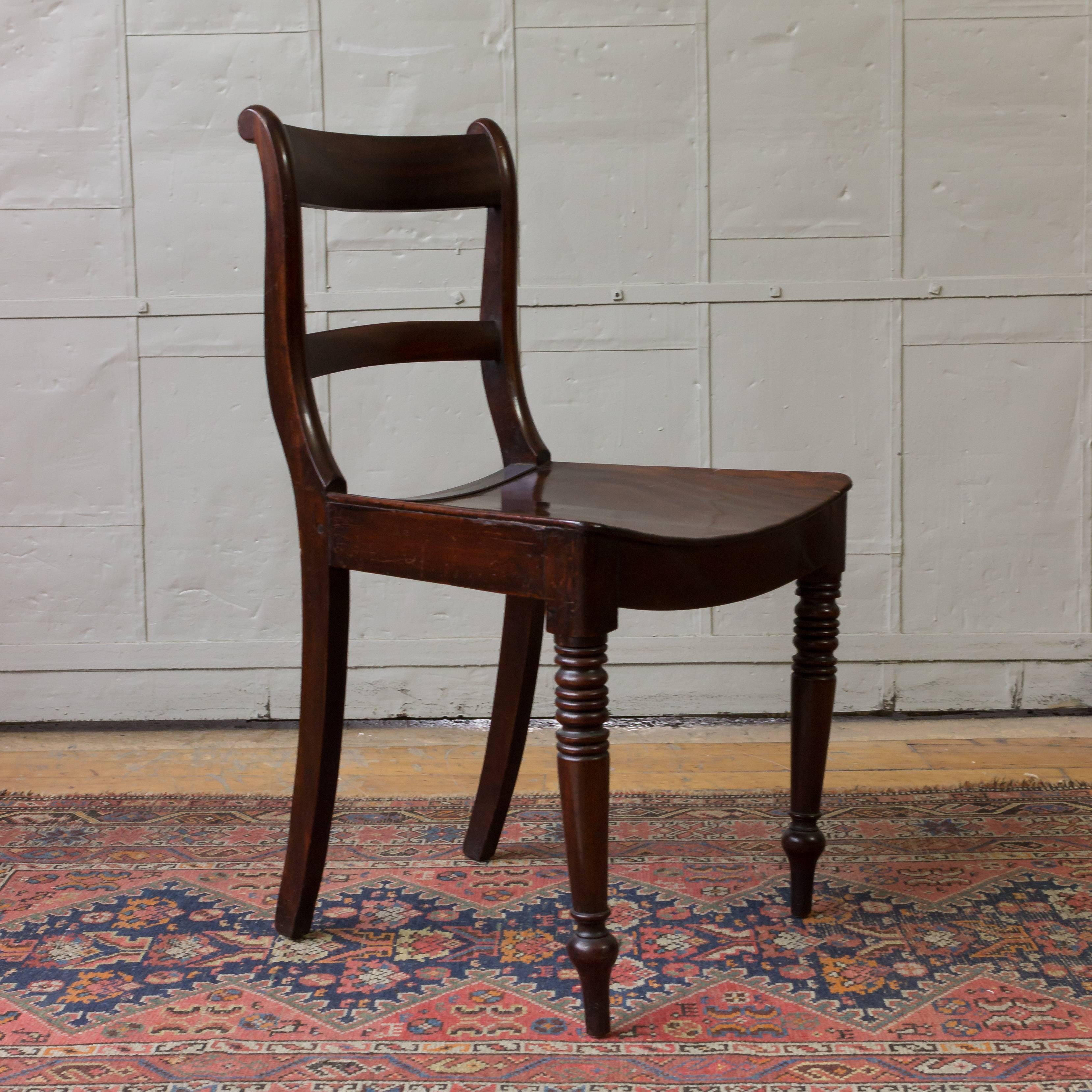 Mahogany side chair with turned legs and curved seat.