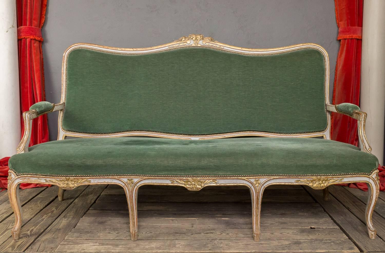 Large late 19th century settee upholstered in a pale green velvet. The frame shows traces of rich gilding. Large seat and high back.

