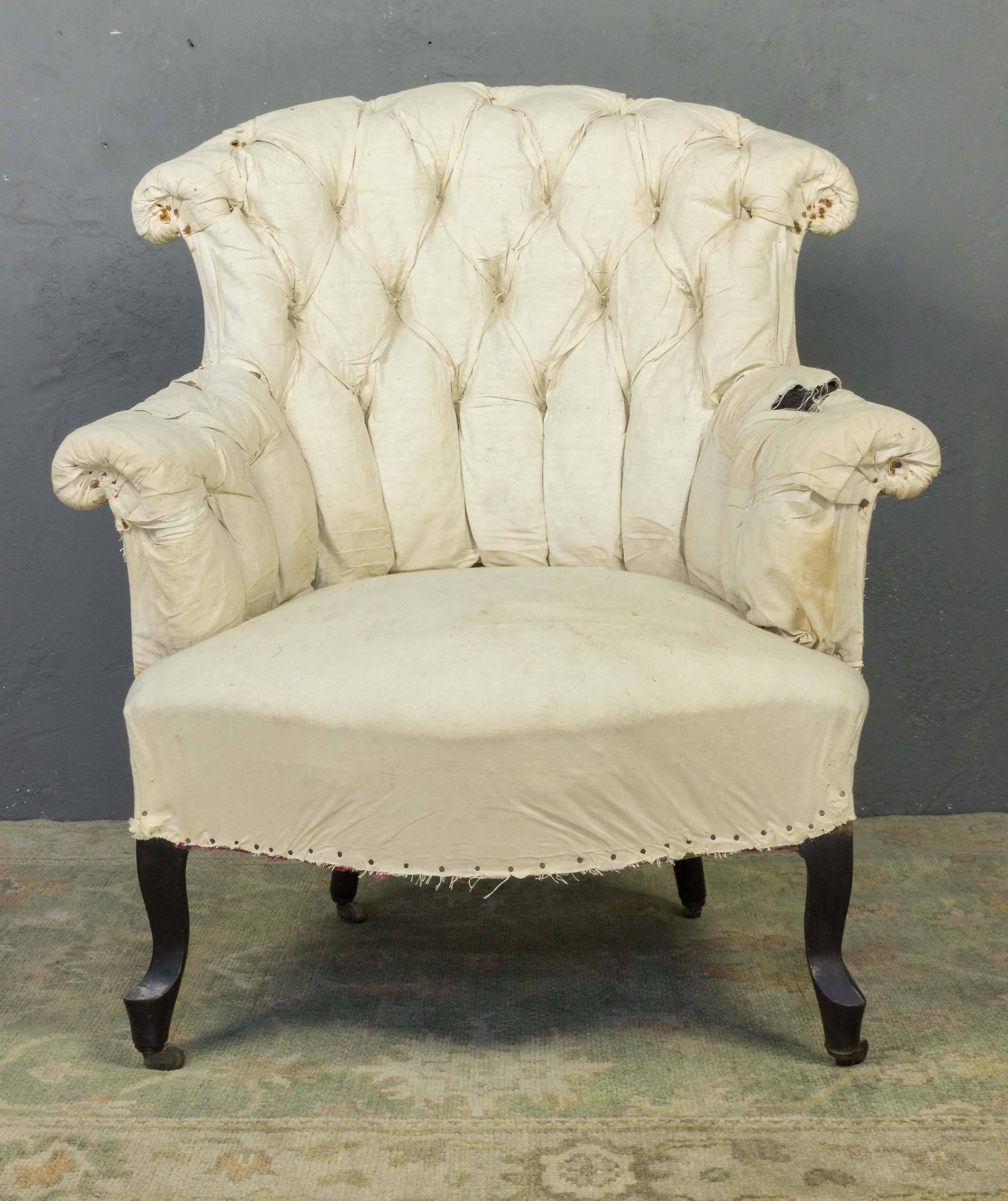 An exquisite pair of French 19th century tufted armchairs with cabriole legs. Capturing the intricate details and romantic beauty of Napoleon III design, these armchairs command attention with their cabriole legs and heavily tufted backs. A graceful