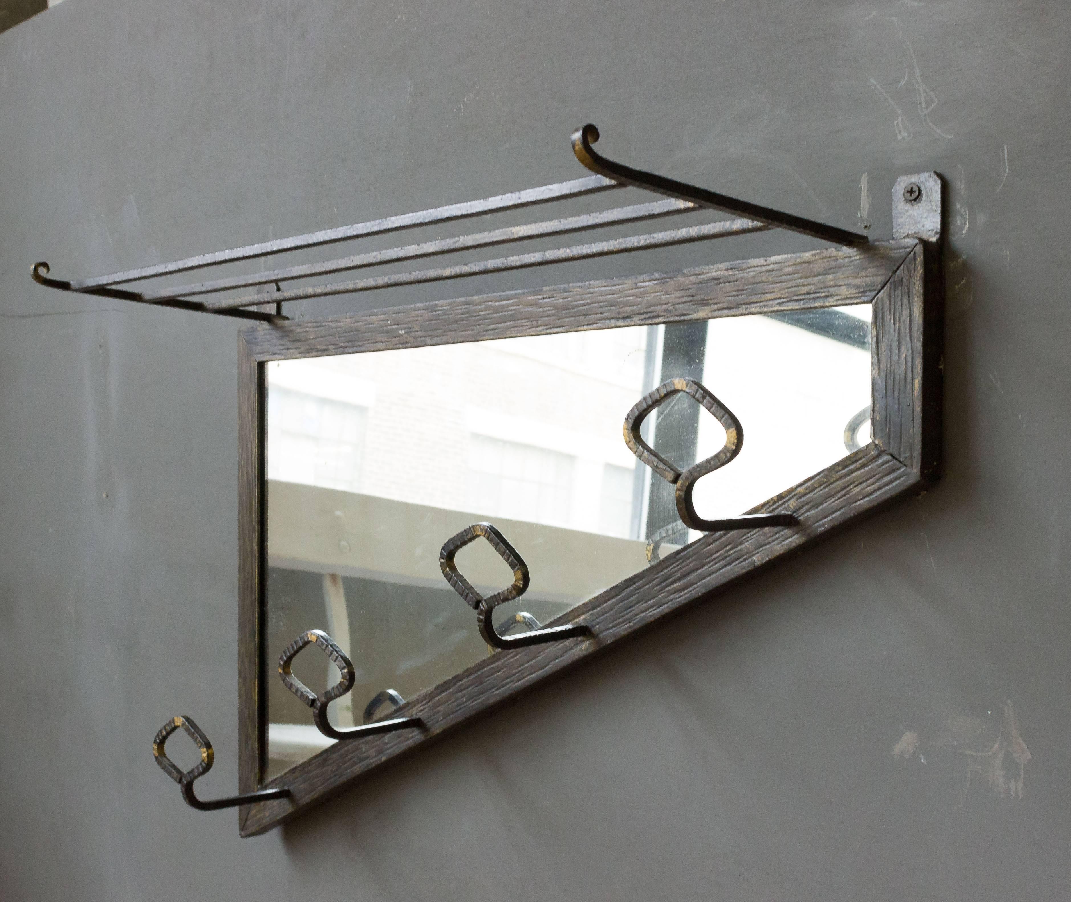 Art Deco period mirror in a tooled and forged iron frame. Four hooks for coats and hats.