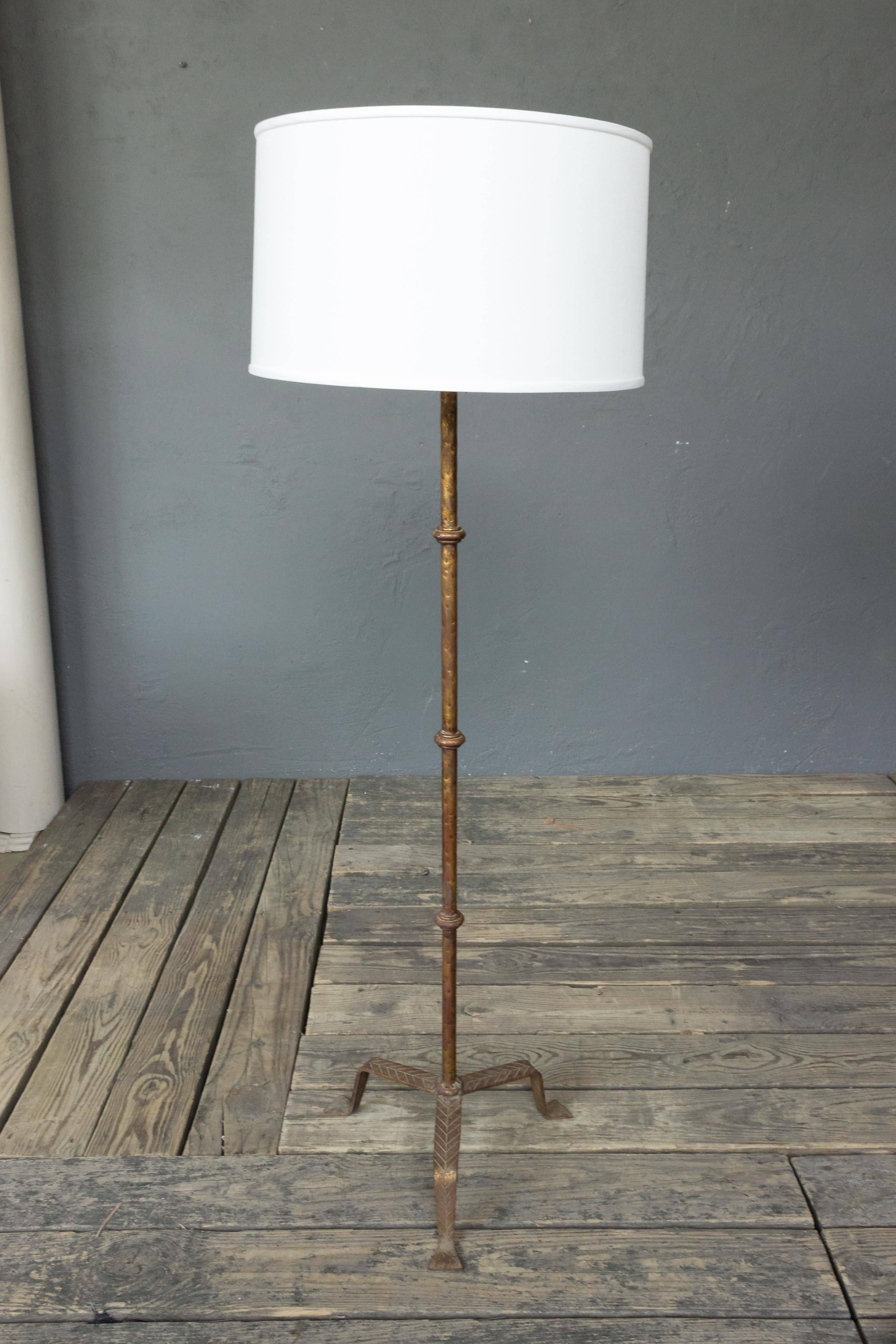 Gilt metal floor lamp with hammered textured details, mounted on a tripod base. Spanish, circa 1950s. Price includes new wiring, not sold with shade.