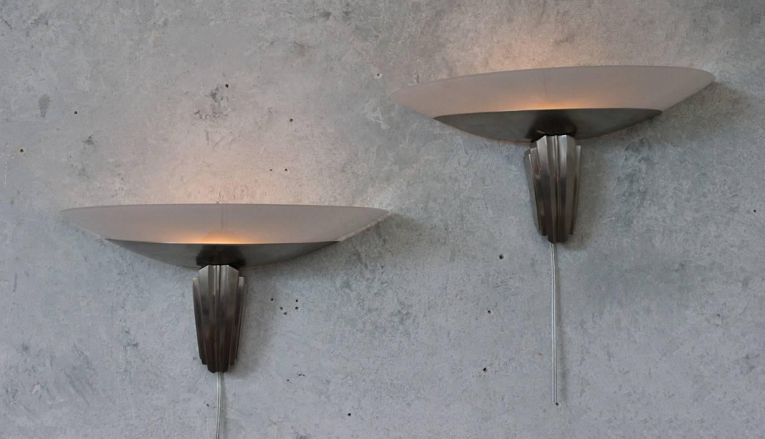 Handsome pair of French Art Deco style metal wall sconces in a brushed nickel finish, with opaque curved glass shades. Design by Jules Leleu.

Ref #: LS1011-01

Dimensions: 9.5