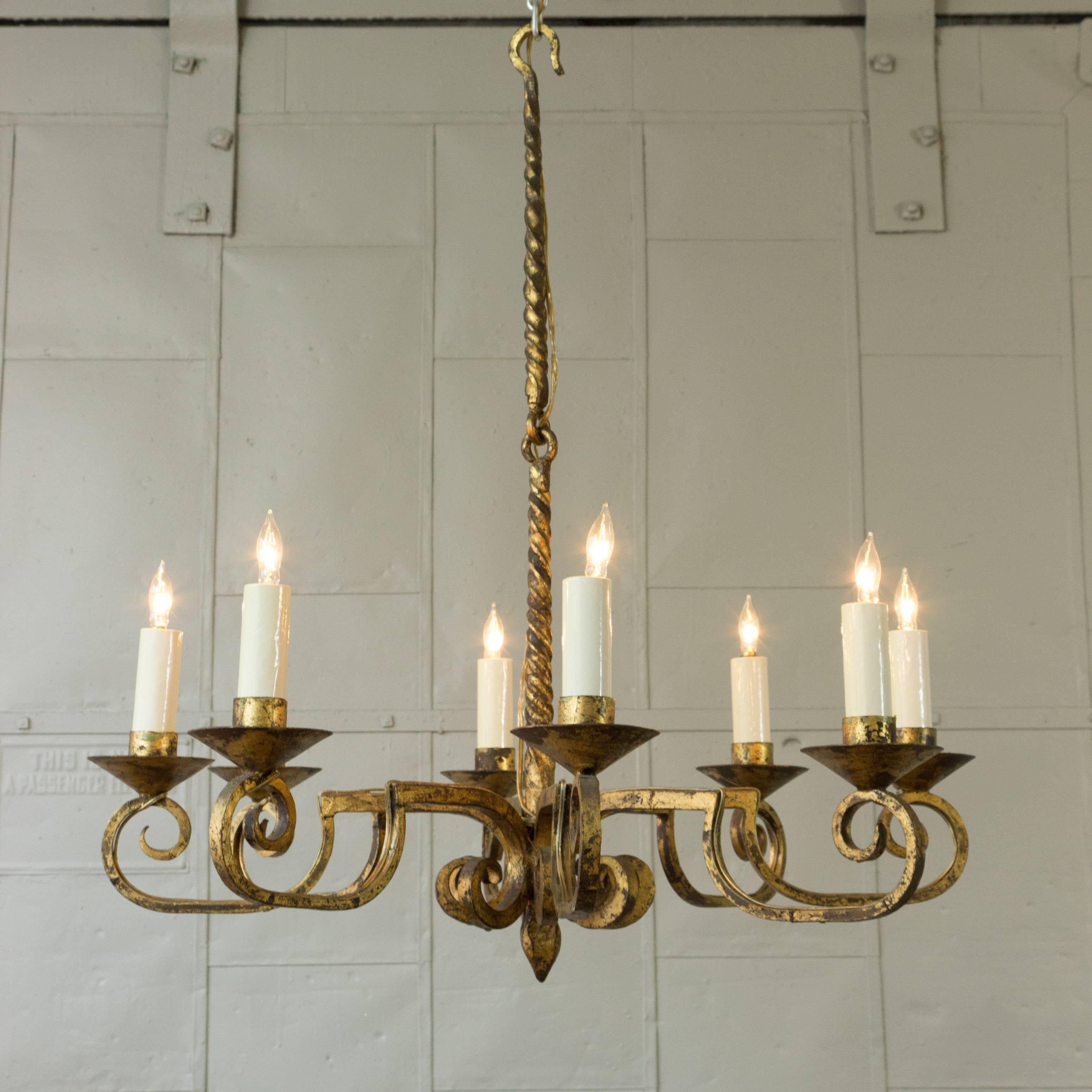 Spanish gilt wrought iron chandelier with eight arms in distressed gilt finish. 
