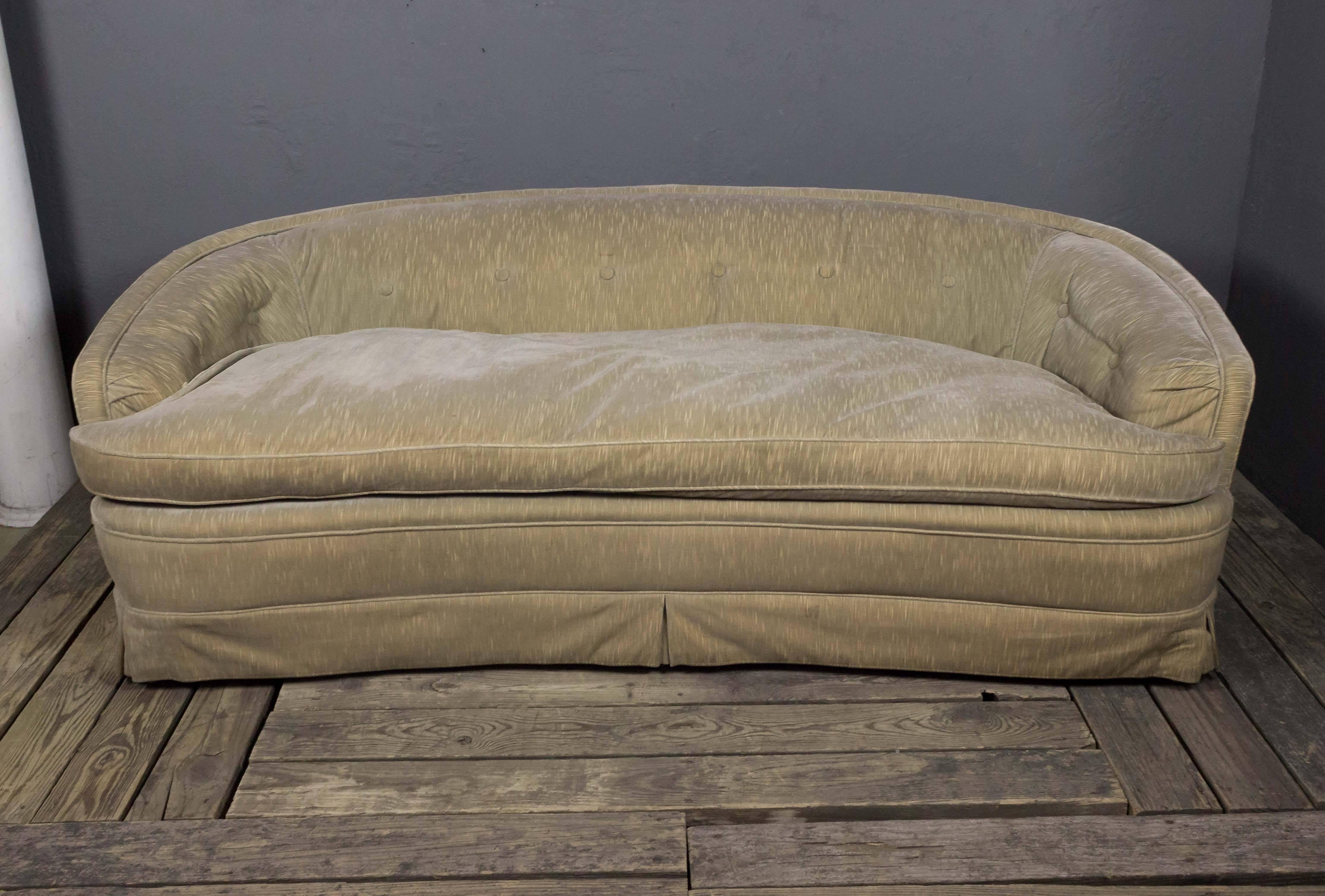 An American mid century sofa with curved back and arms. Make a bold statement in your home with this Mid-Century Modern sofa. Featuring a curved back and arms and upholstered with a skirt and loose seat cushion, this sofa is ready for use - though