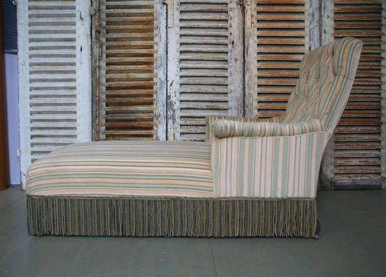 French 19th century chaise lounge upholstered in a striped fabric with contrasting bullion fringe. The upholstery is in good condition bit not recent.