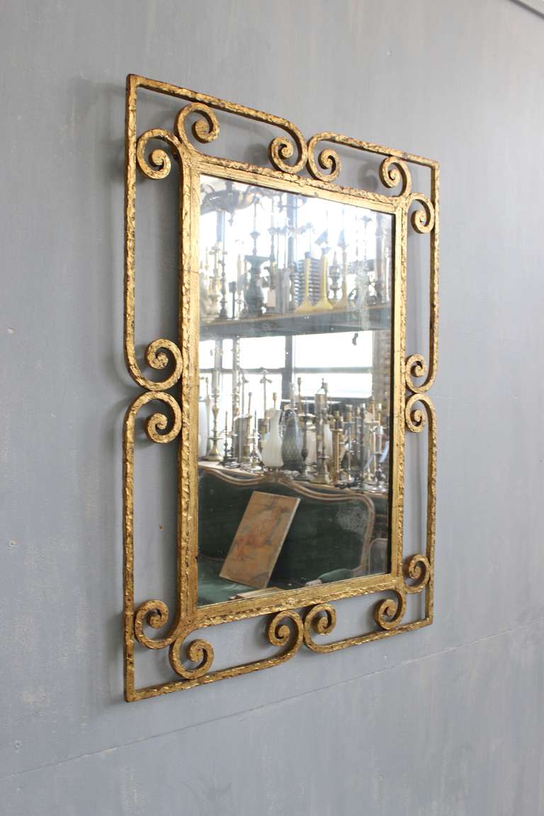 Very interesting gilt iron mirror with scroll frames. Original mirror and hand applied gilt finish.