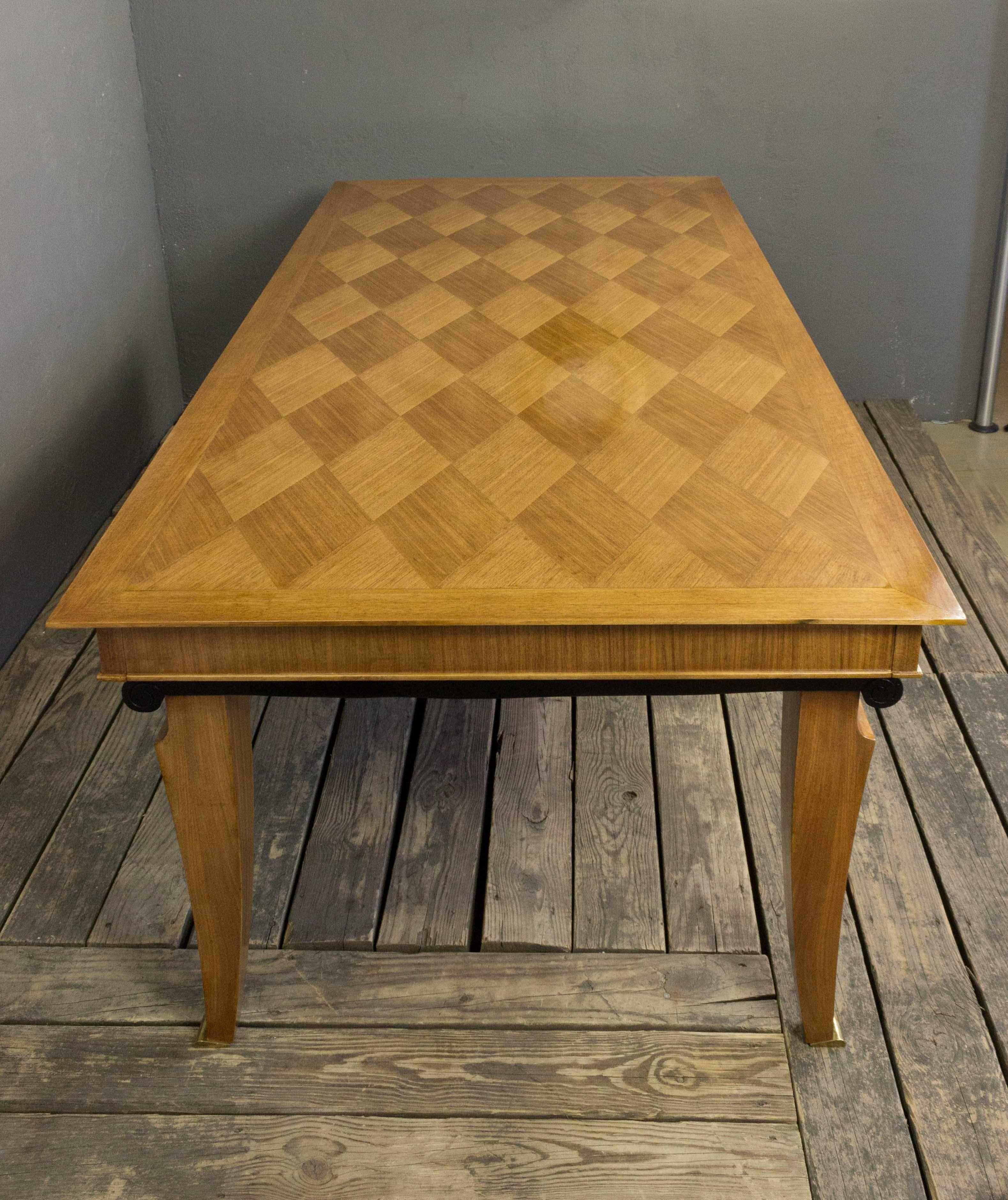 This French mahogany veneered dining table is a stunning piece of Art Deco furniture from the 1940s. The basket weave marquetry top is a true work of art, and the ebonized highlights add a touch of elegance to the overall design. The legs are