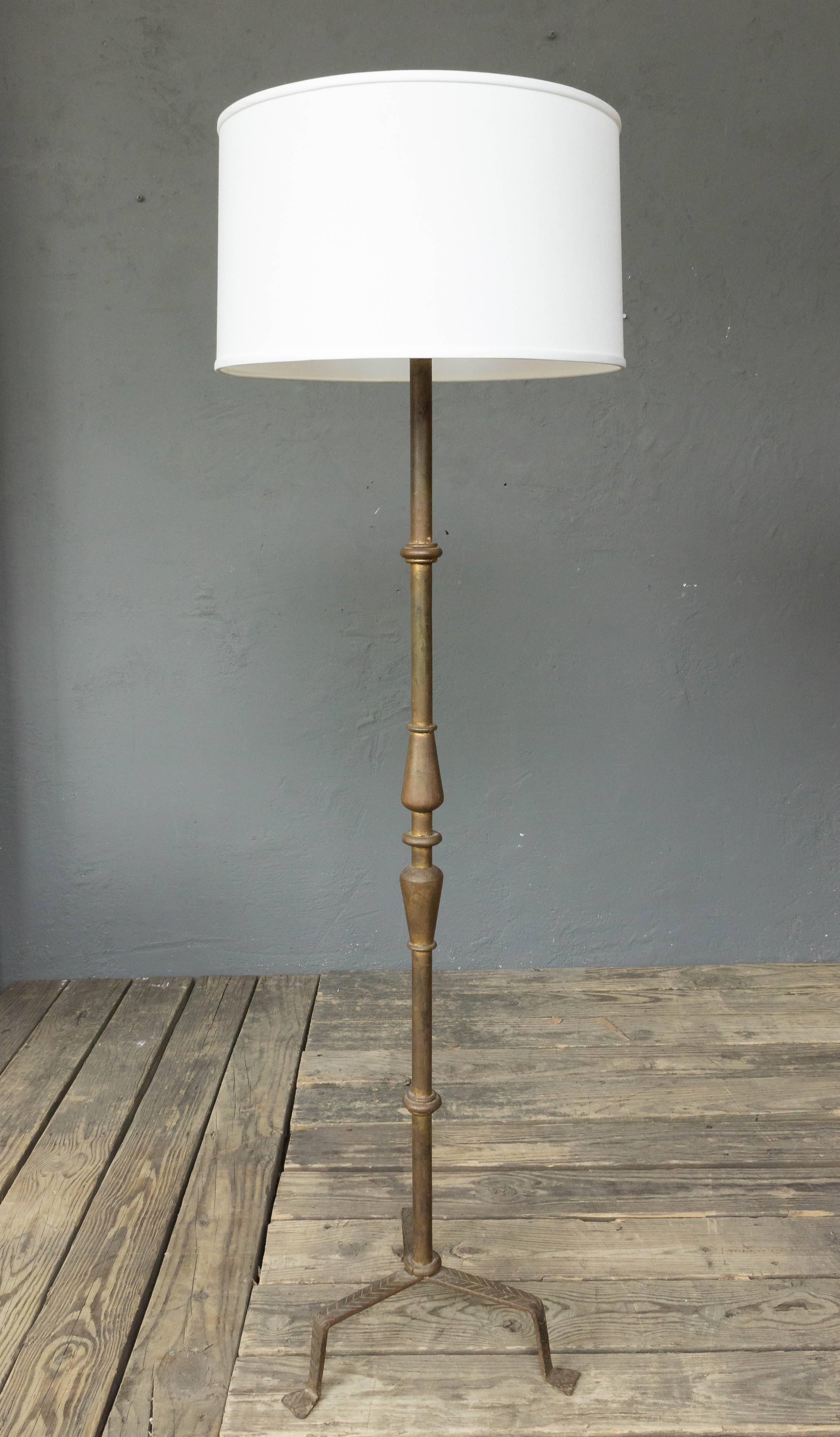 Gilt iron floor lamp with turned parts and hammered iron detail. Spanish, 1950s. 

Not sold with shade.