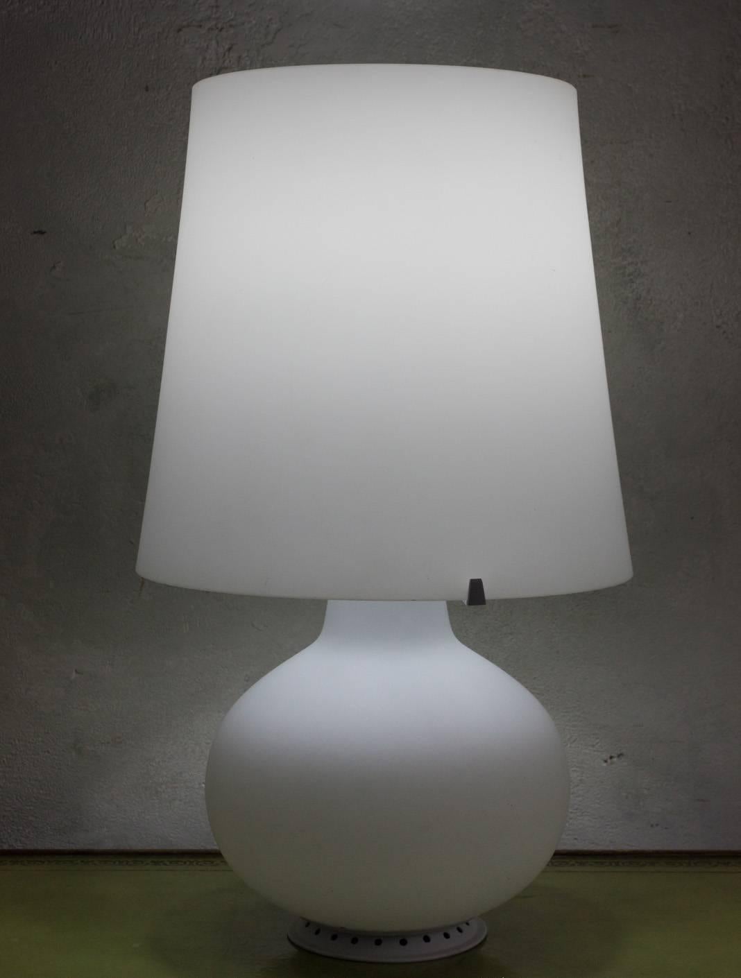 This Italian white glass lamp by Max Ingrand is a remarkable piece of mid-century design from the 1960s. Its minimalist lines and simple form give it a timeless charm, accentuated by the sophistication and elegance of the white glass shade. The lamp