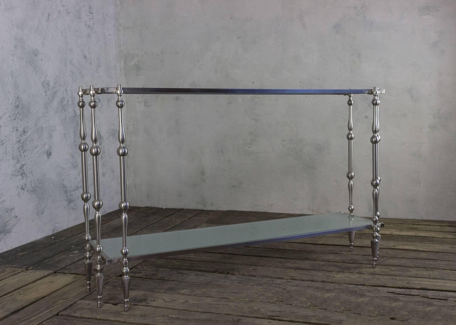 This 1980s French vintage console table is a remarkable piece of furniture that combines practicality with an elegant design. Featuring two shelves made from thick sandblasted glass, it offers both an upper and lower surface for displaying your