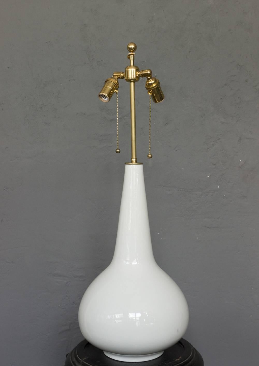 This French 1960s lamp is a wonderfully proportioned piece crafted from white glazed ceramic. It has been recently rewired with a double cluster for optimal functionality. It is in very good condition, ready to enhance any space with its timeless