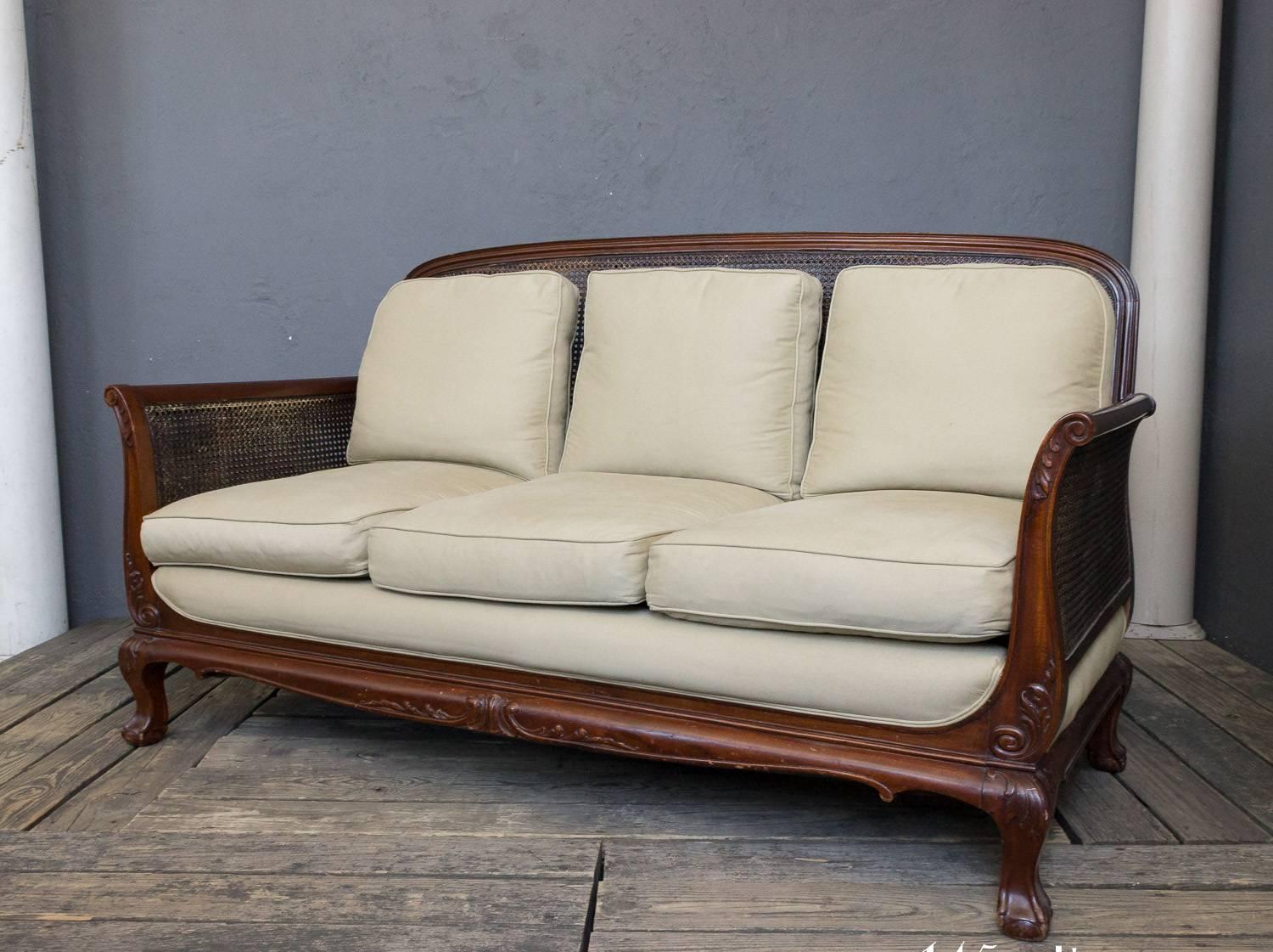 19th century Anglo-Indian mahogany sofa with caned back and sides upholstered in a cotton twill with down wrapped back cushions. The sofa is in good condition, the frame needs some touch ups to the finish.  The fabric shows normal age but can easily