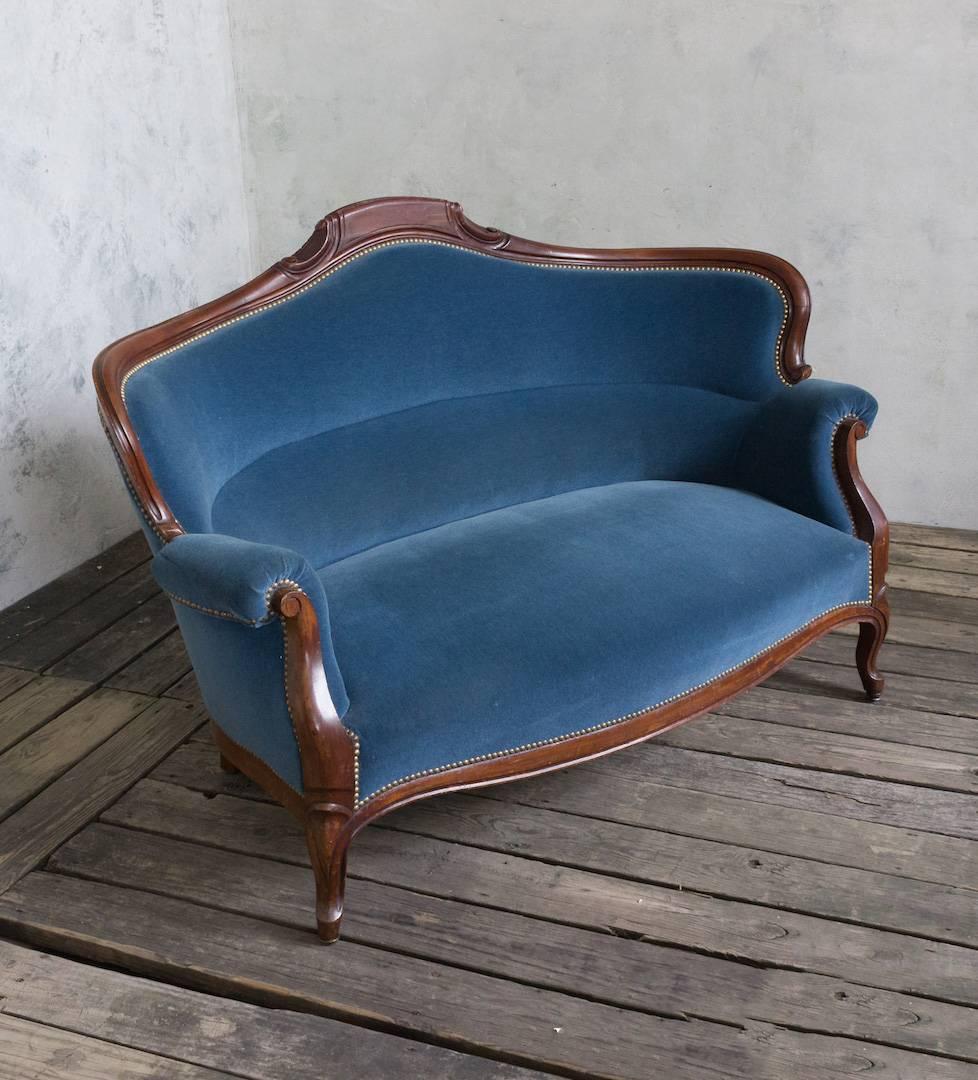 Late 19th century French mahogany sofa upholstered in blue velvet with brass nailheads.