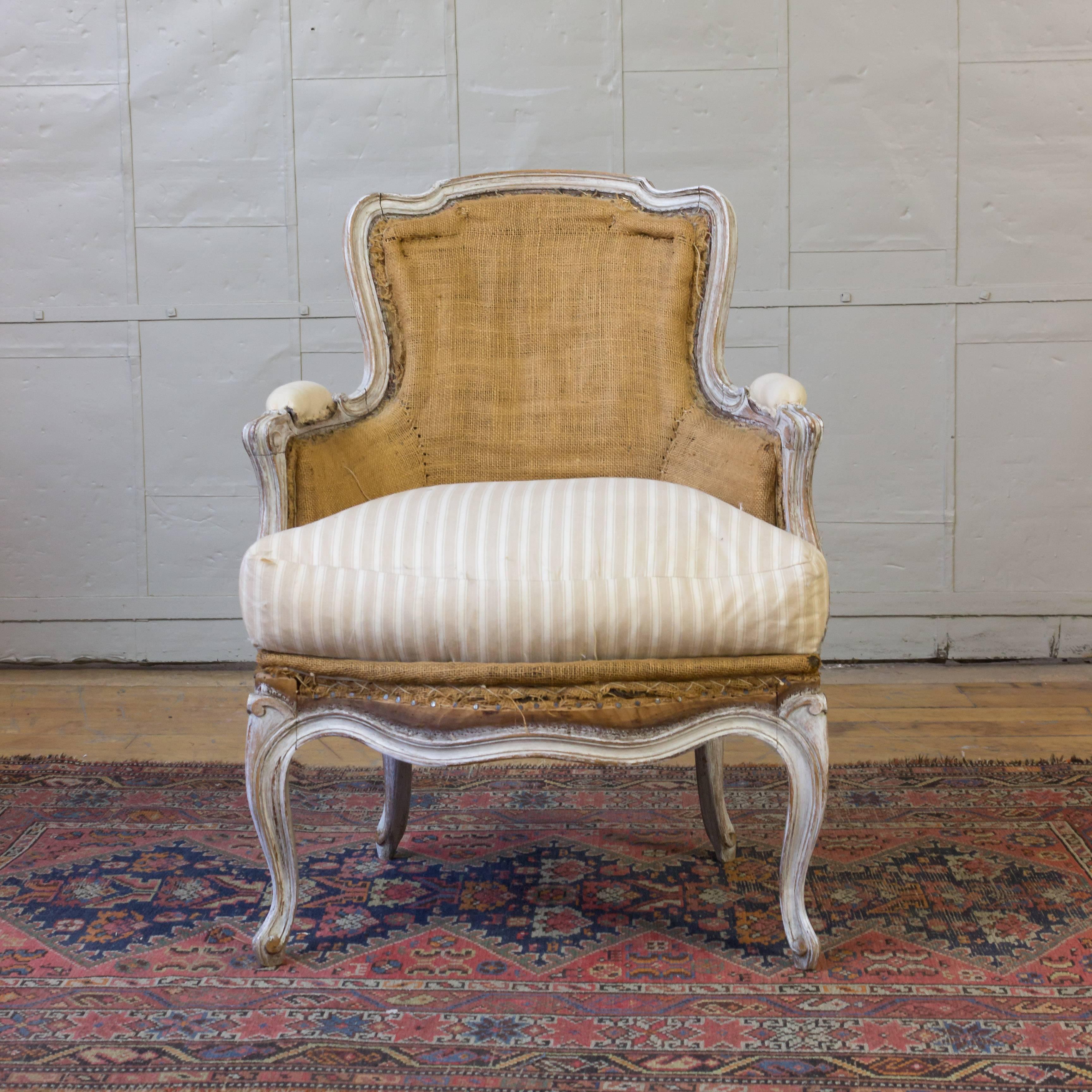 A pair of Louis XV style armchairs with painted wood trim in burlap with down cushions.