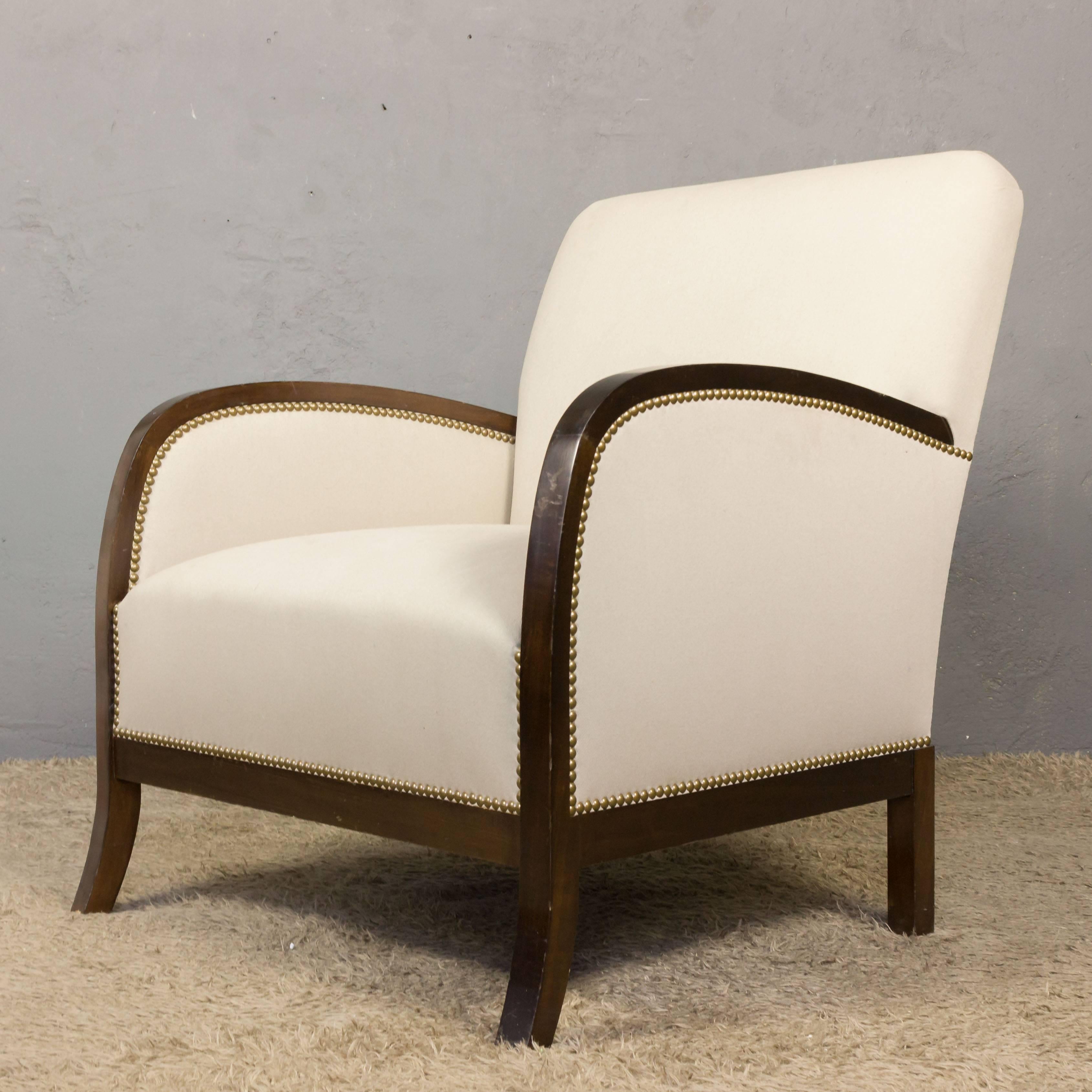 An exceptional reproduction of a French 1930s armchair. Bring a touch of classic French elegance to your home with this exquisite reproduction of a 1930s Art Deco club style armchair. Upholstered in beautiful fabric with nailhead detailing and