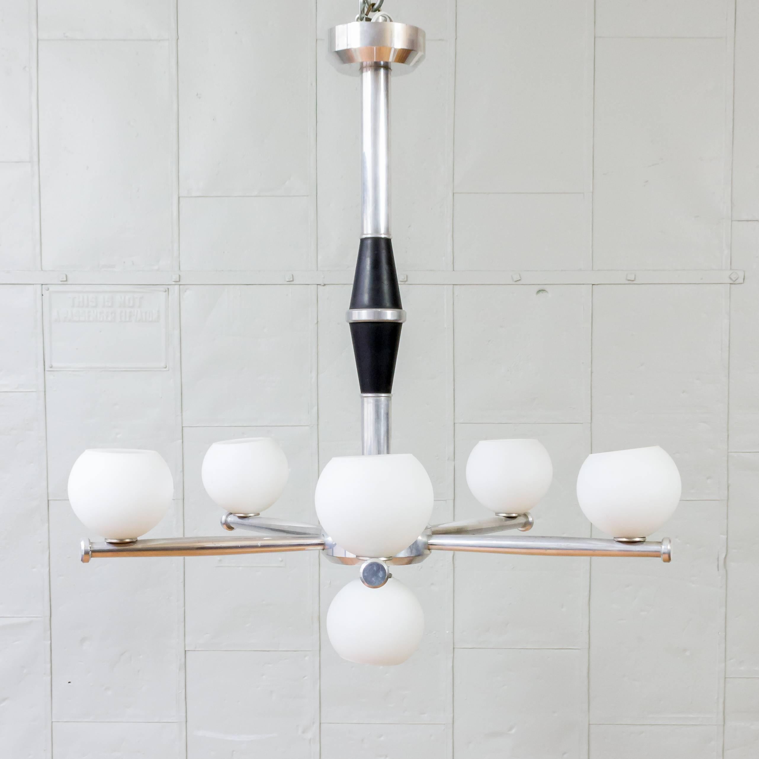 This remarkable French 1950s mid century modern cast aluminum chandelier features six frosted glass globes. This stunning piece is in very good vintage condition and has recently been rewired, ensuring both functionality and safety. Standing at an