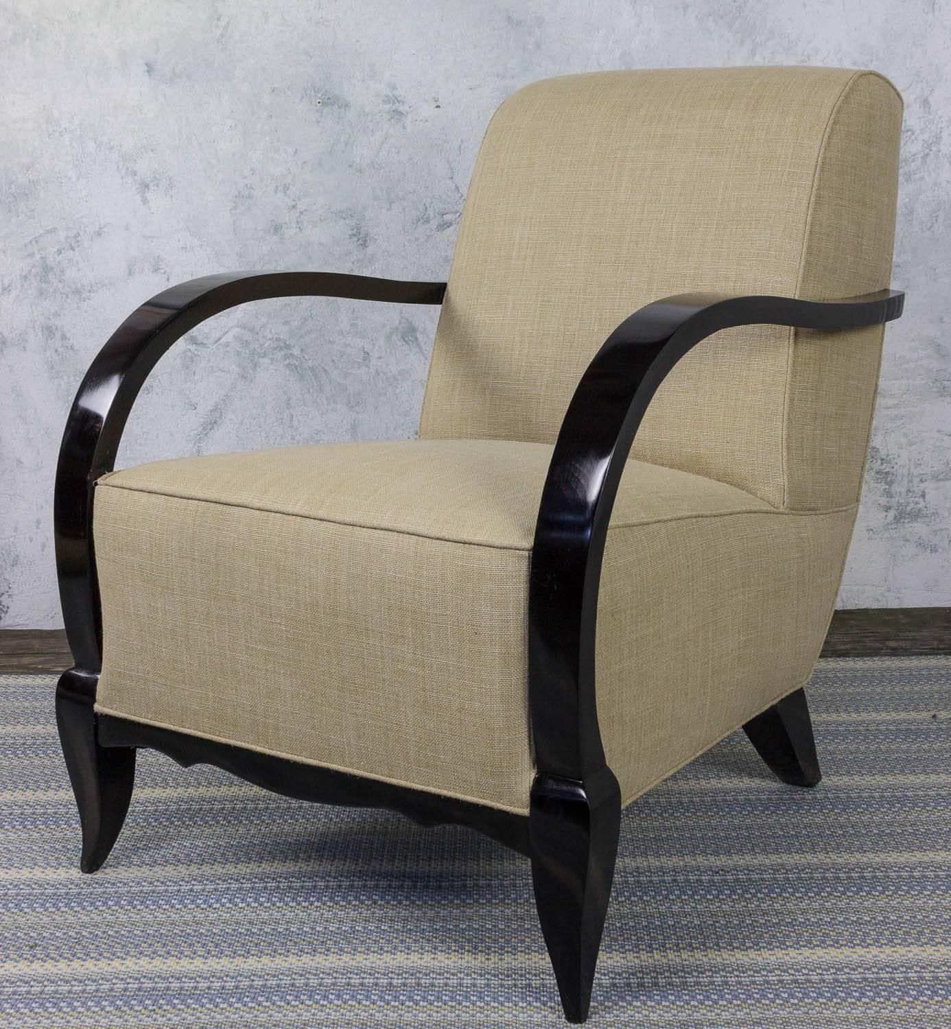 A stunning pair of French 1940s Art Deco club style armchairs with ebonized arms and legs. These classic chairs are in excellent condition and are newly upholstered in durable Belgian linen. The gorgeous ebonized arms and legs make them the perfect