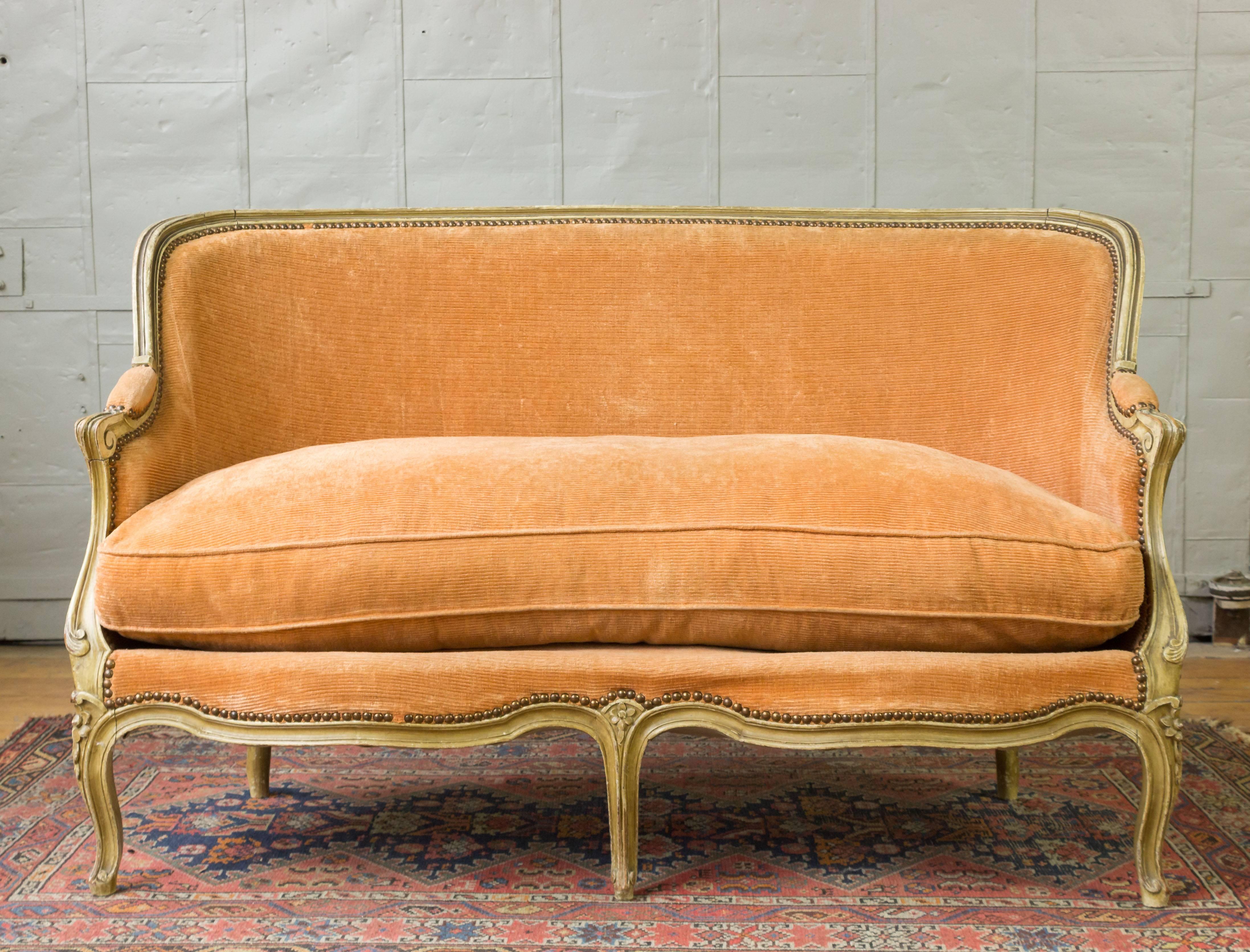 Well-proportioned small settee upholstered in velvet with loose seat cushion and high back. Original patinated wood finish, French, 1920s.

