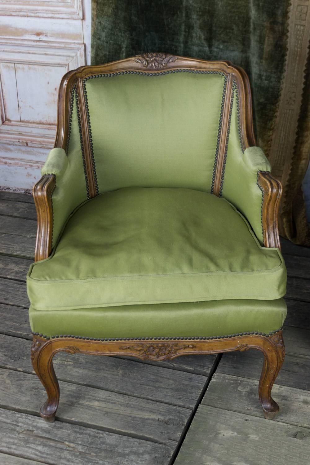 Pair of Louis XV style armchairs with fruitwood exposed frame and cabriole legs in a green fabric and loose seat.