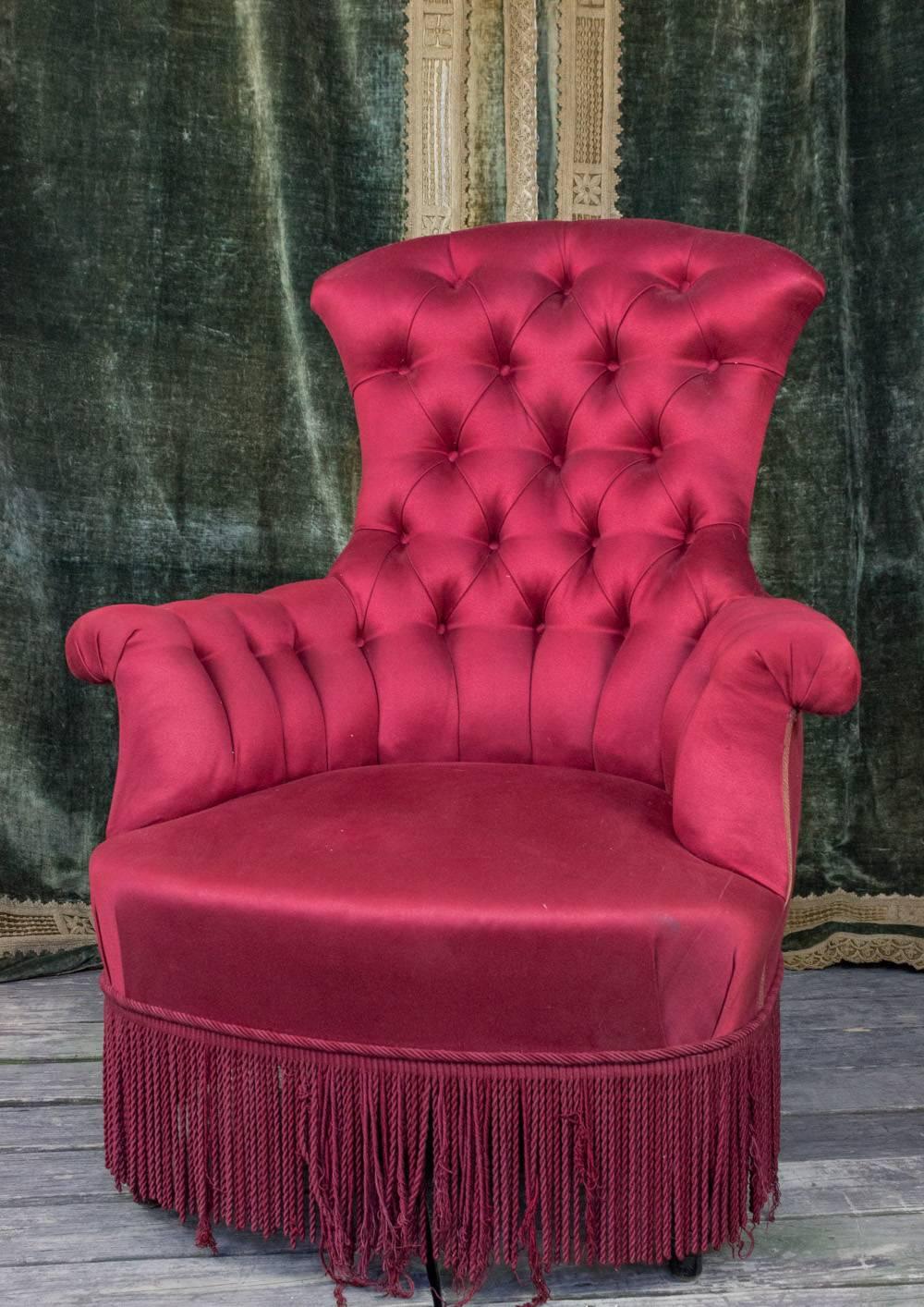 High back tufted Napoleon III chair in red satin with matching bouillon fringe, French, 19th century.

Not for sale. Rental only.