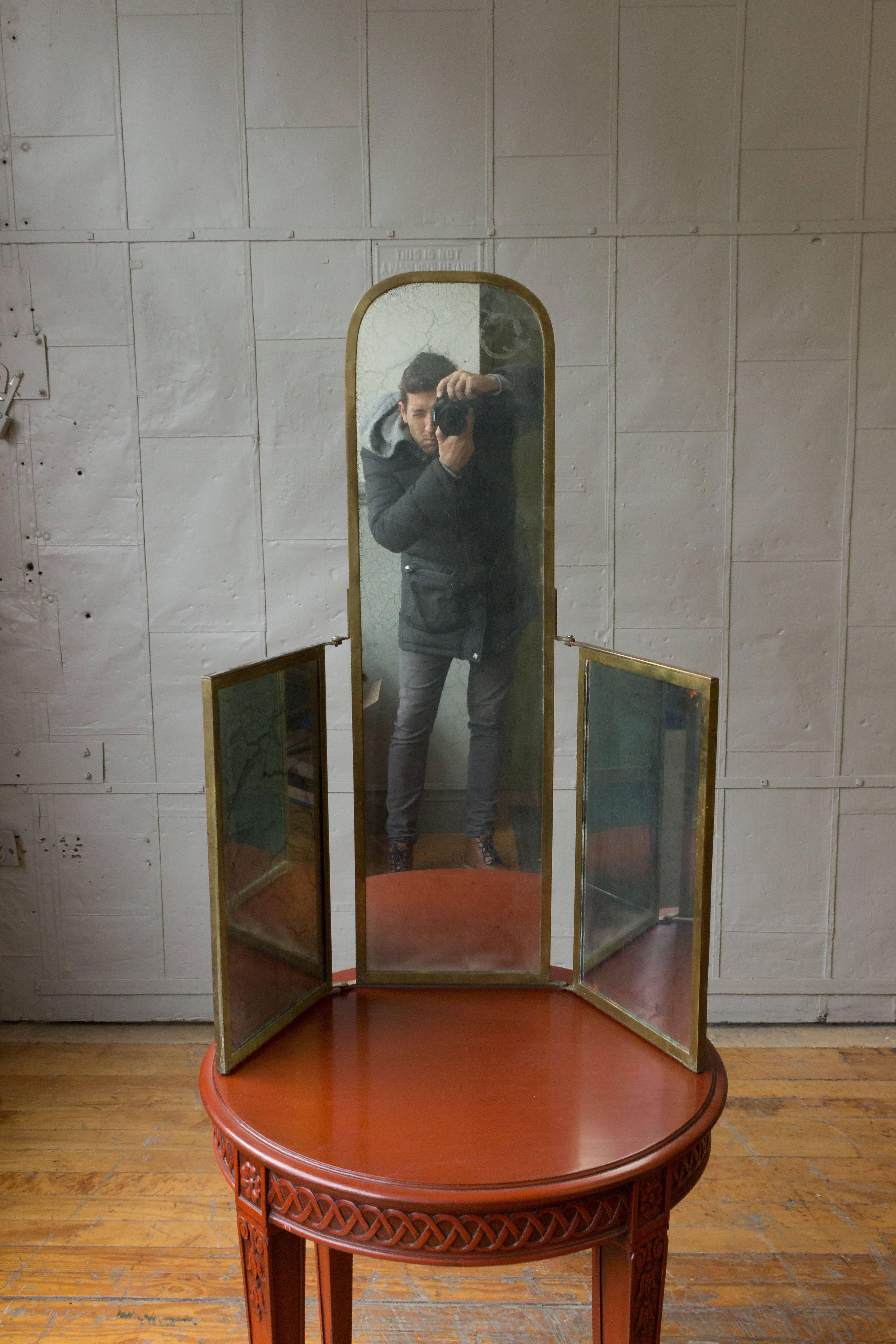 An interesting and unusual mirror with original and distressed mirror and patinated brass frame. The mirror can either be wall hung or can be used free standing. 

Center panel is 40” H x 11.5” W.
Side panels are 20” H x 12” W.

  