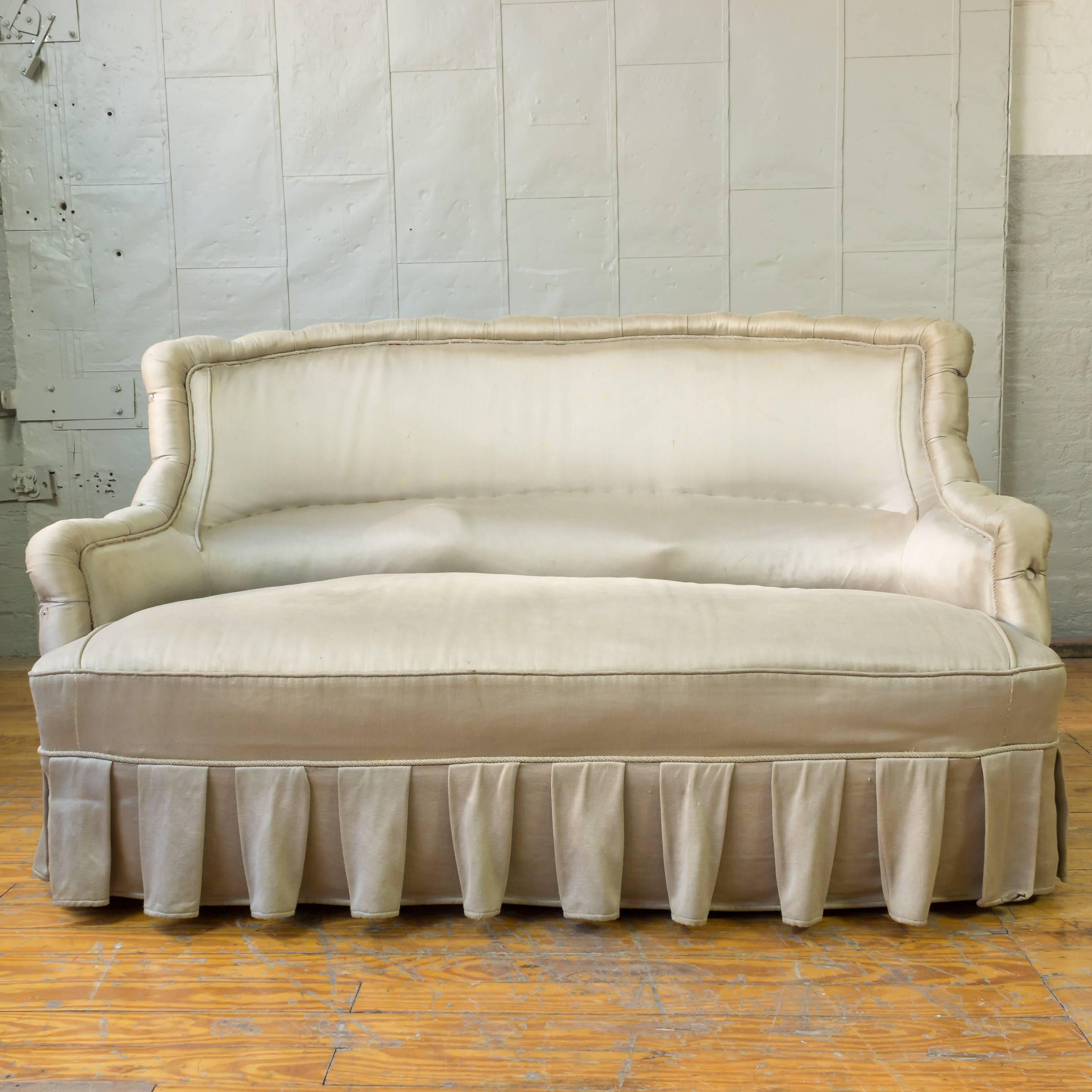 French 19th Century Settee upholstered in silvery grey satin. The sofa needs to be reupholstered , sold as is.
