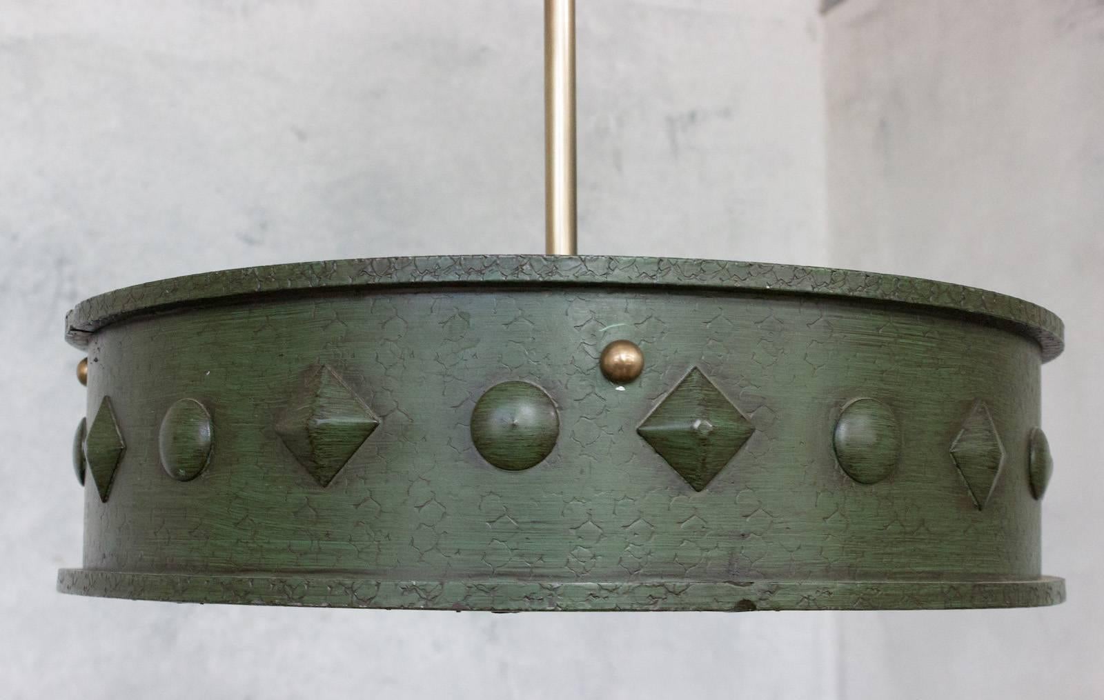 Ce plafonnier unique en métal français des années 1950 présente un baldaquin vert patiné à la main avec des décorations en relief entourant un insert en verre dépoli. Il est accompagné d'une tige de suspension assortie. Le luminaire a été récemment