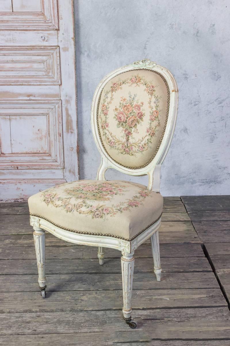 A beautiful set of three French 19th century Louis XVI style side chairs with petit point upholstery. This set of French Louis XVI style side chairs is a stunning addition to any space. The original patinated, finished frames boast beautiful carved