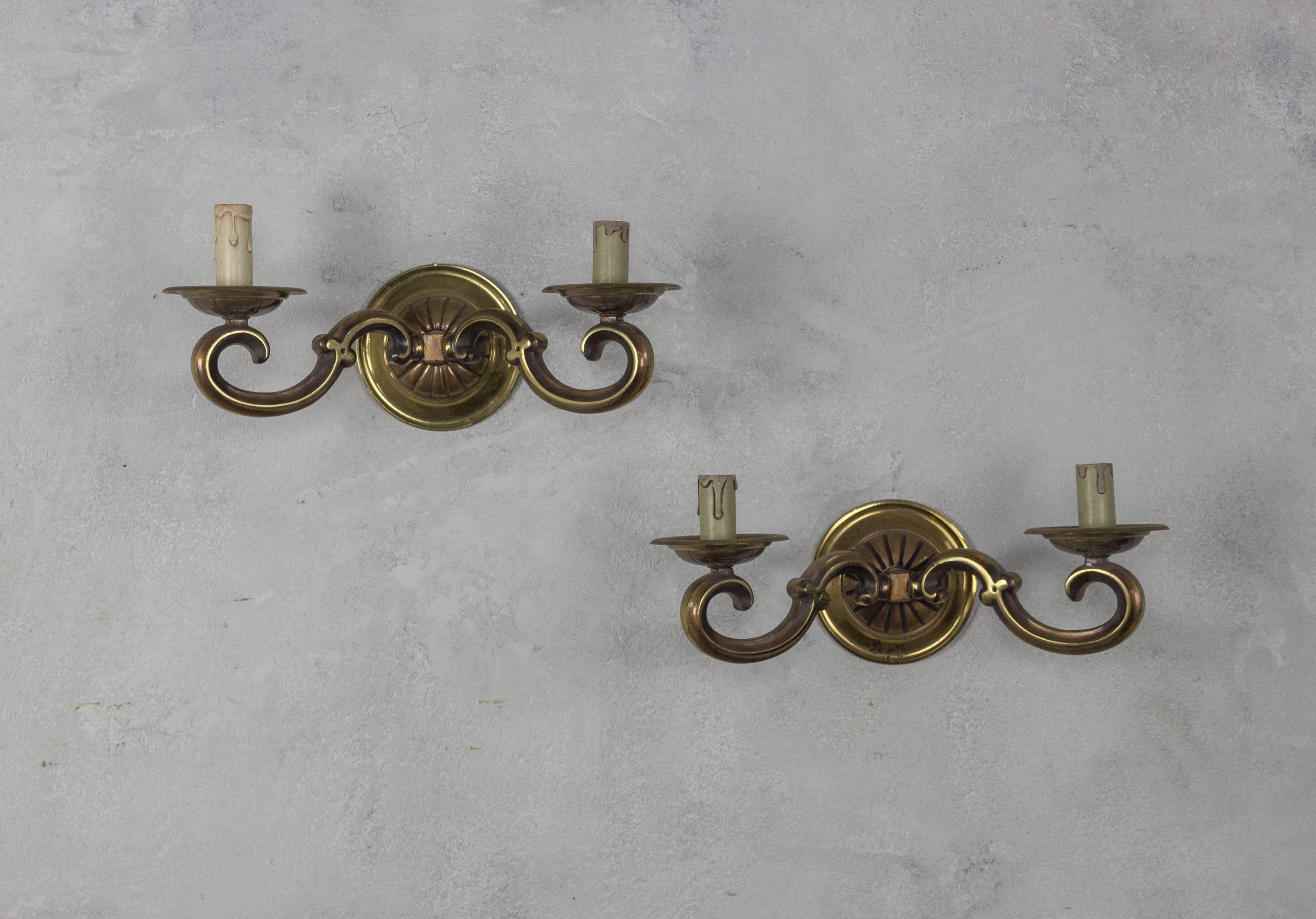 Questa coppia di appliques in bronzo dorato, provenienti dalla Francia degli anni '40, è un esempio straordinario di illuminazione vintage. Ogni applique è dotata di due bracci ed è rifinita in bronzo dorato che ha mantenuto la sua lucentezza nel