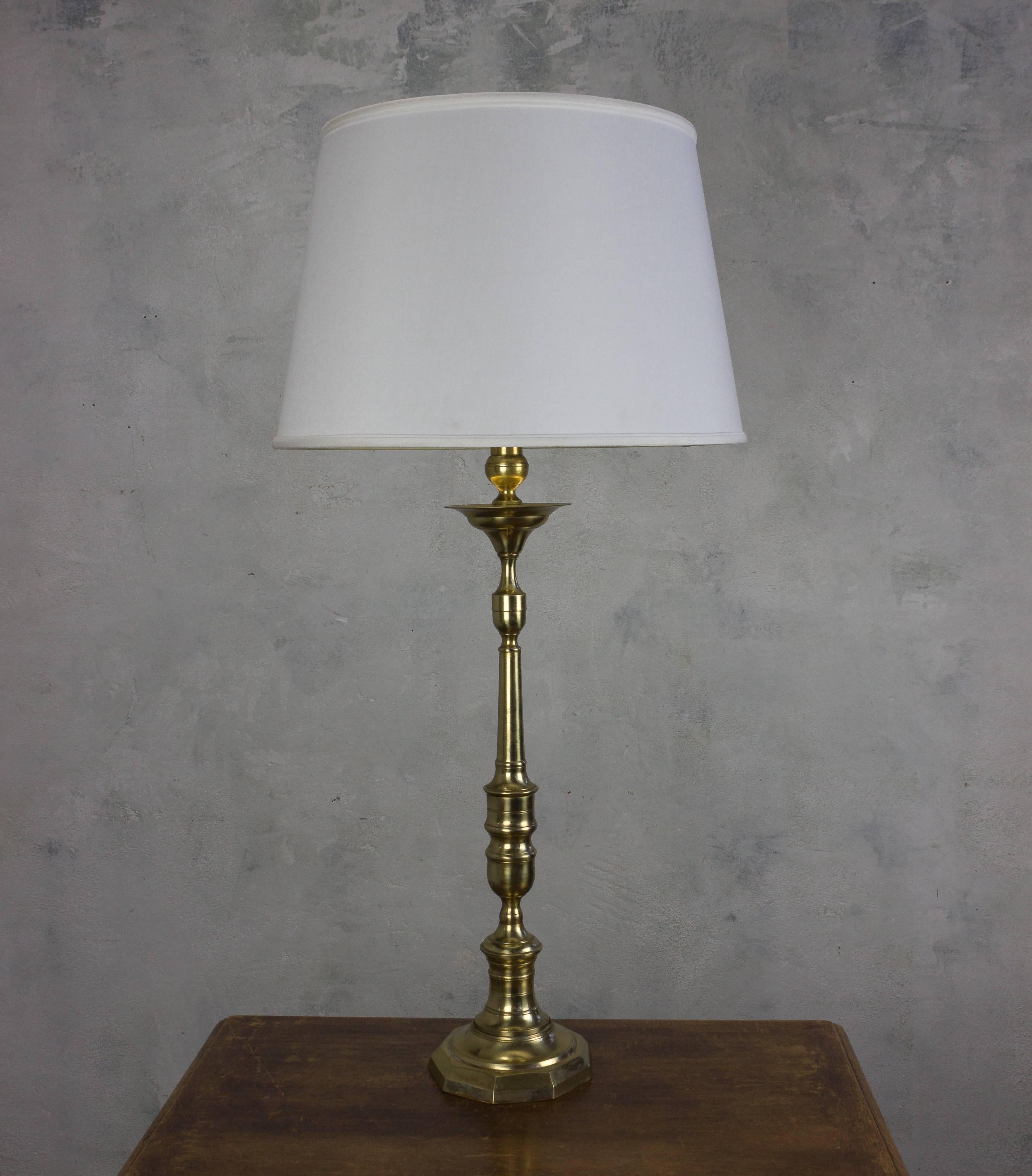 This stunning, tall table lamp exudes elegance and sophistication. Hailing from 1940s France, it boasts a breathtaking combination of turned bronze and brass components with a soft English brass finish. The lamp stands tall at 36 inches, commanding