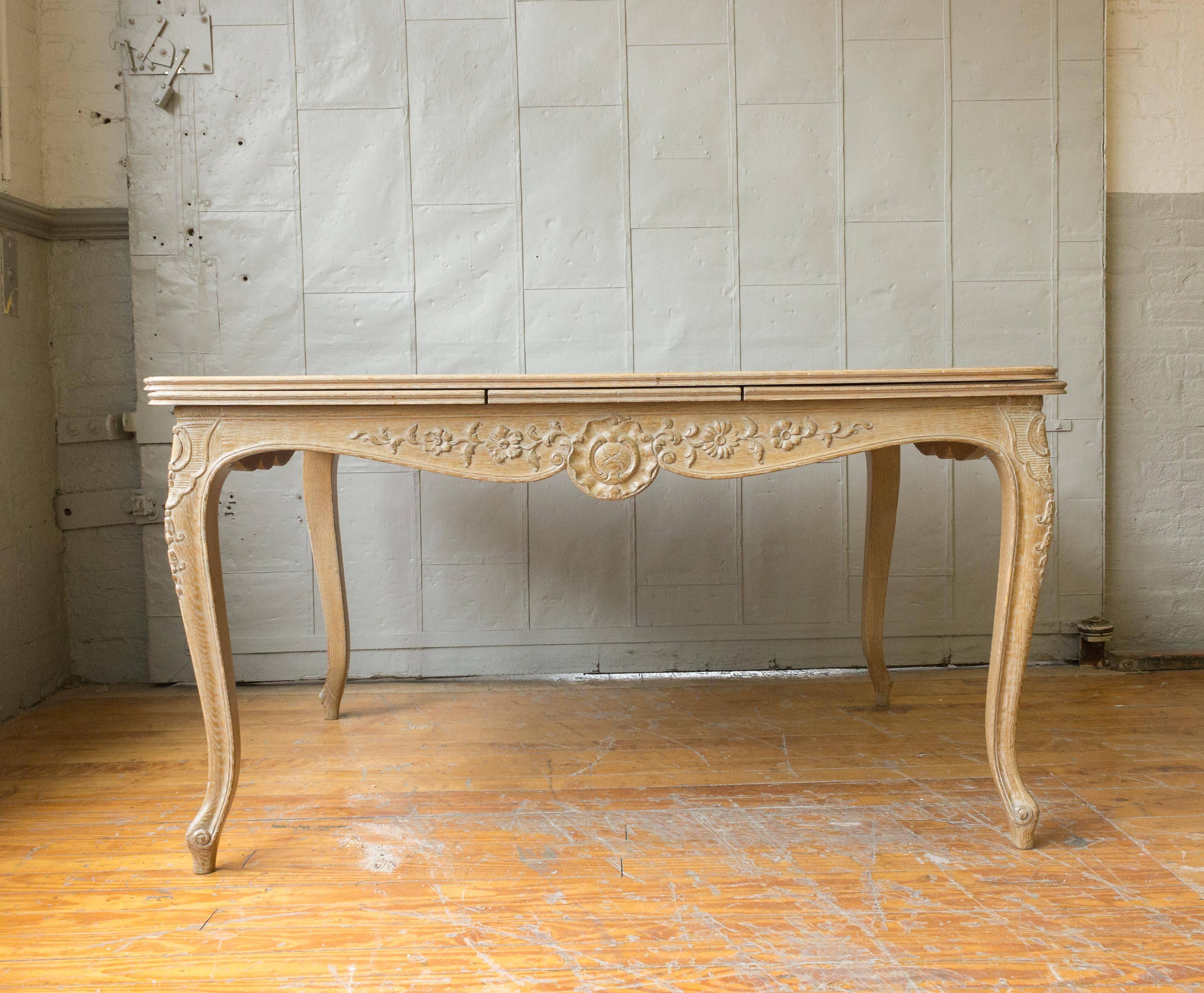 This elegant French 1950s Louis XV style dining table is a true beauty, with its delicate soft limed oak finish lending an air of sophistication to any dining room. The two 20 inch leaves are conveniently stored inside the table, so it can be opened