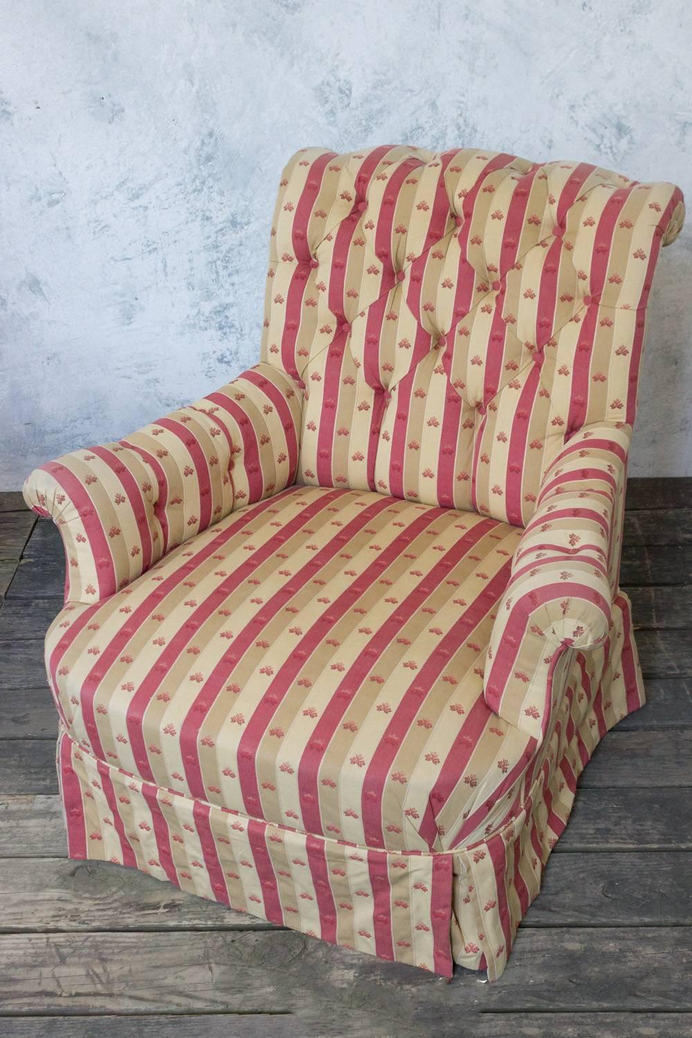 A striking pair of Napoleon III armchairs in a red and tan striped fabric. Crafted with quality and attention to detail not seen in modern-day furniture, these beautiful large scale chairs will make a statement in any room. Upholstered in a classic