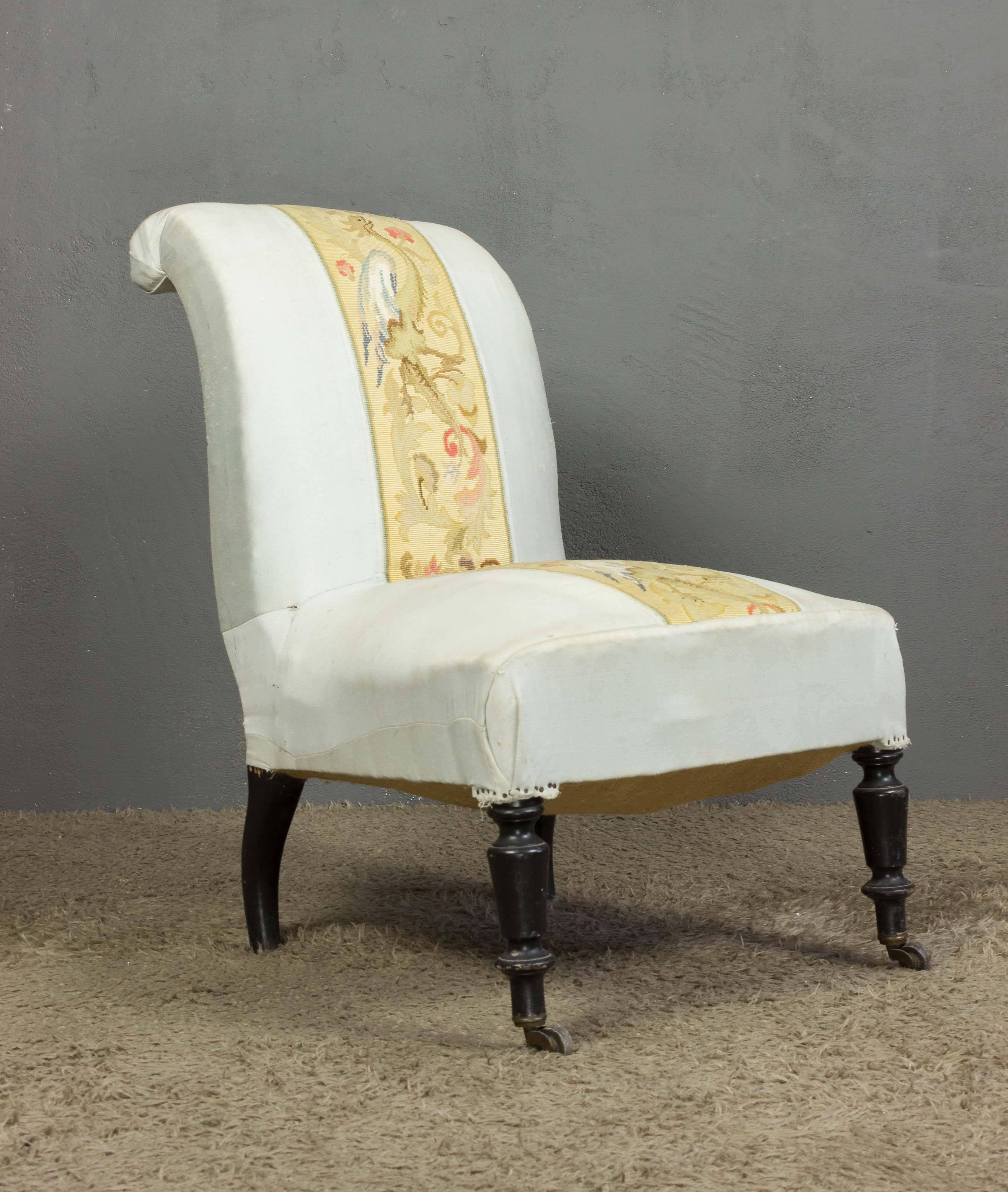A lovely 19th century French Napoleon III slipper chair. This magnificent French slipper chair features a scrolled back, and has been upholstered in a light fabric, with an embroidered panel on the back and seat. In good vintage condition, this