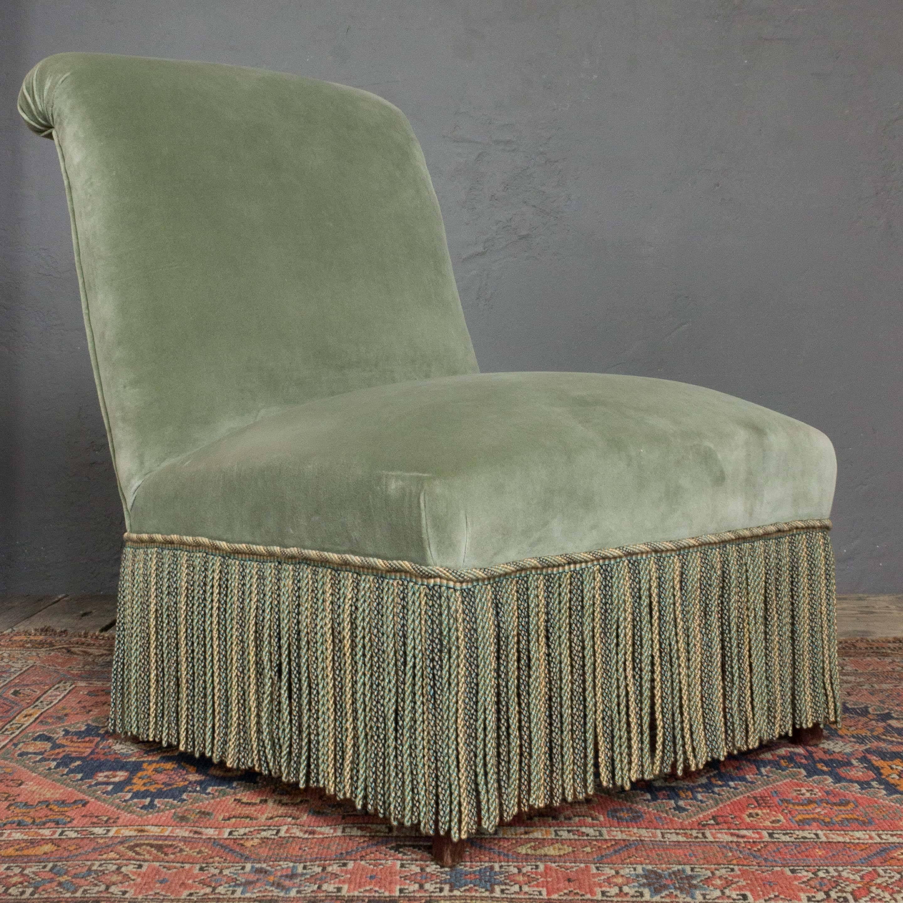 Handsome pair of Napoleon III slipper chairs in a soft olive green velvet with bullion fringe.