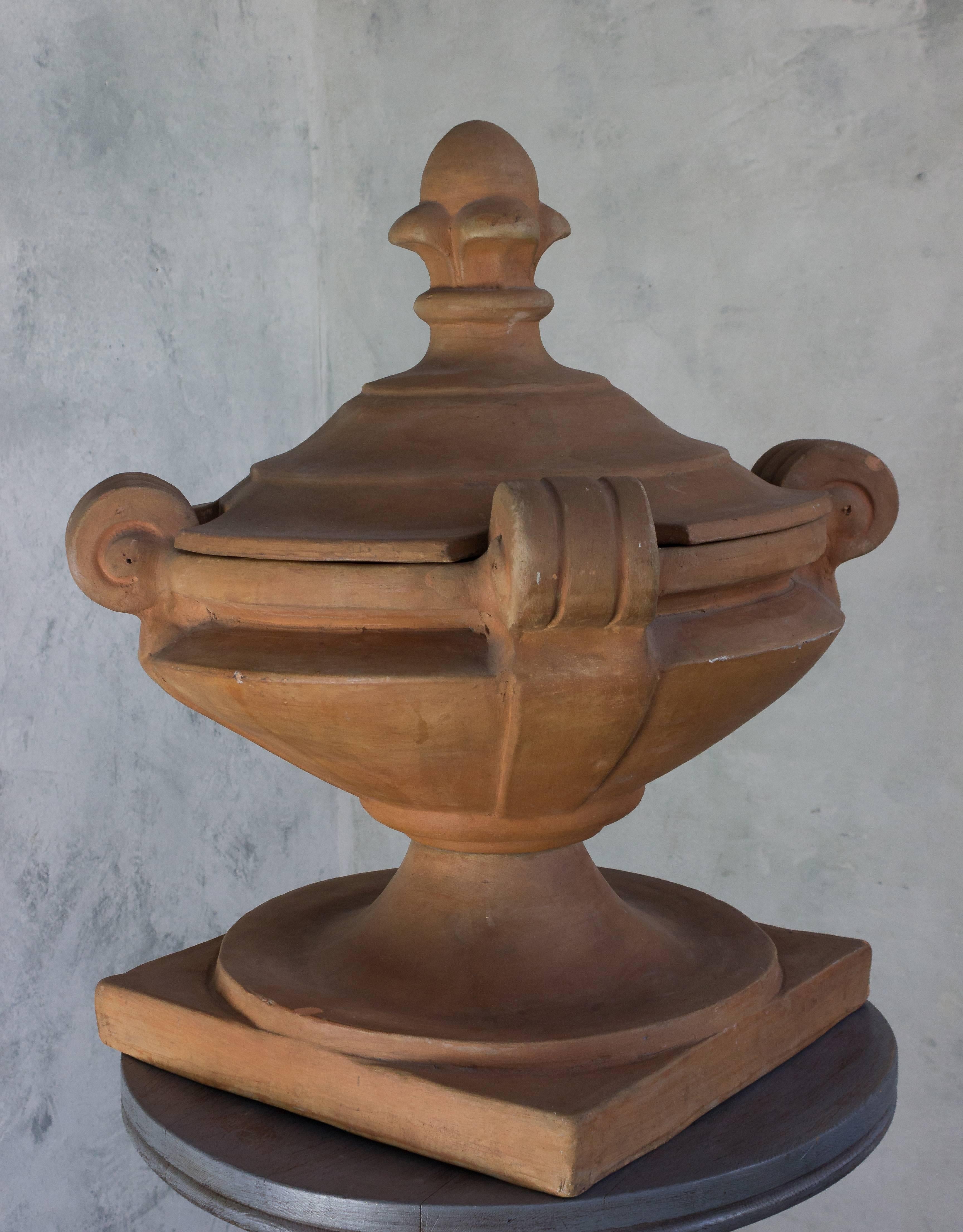 Add a touch of France to your home with this charming 1920s decorative terra cotta covered urn. This timeless piece will bring charm and sophistication to any living space, and its classic design gives it a unique appeal. Whether you choose to use