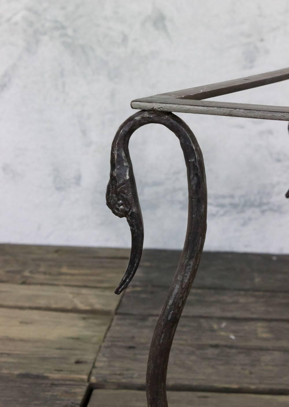 French, 1950s iron coffee table with swan head legs and a gold, amber and brown swirled marble top.
